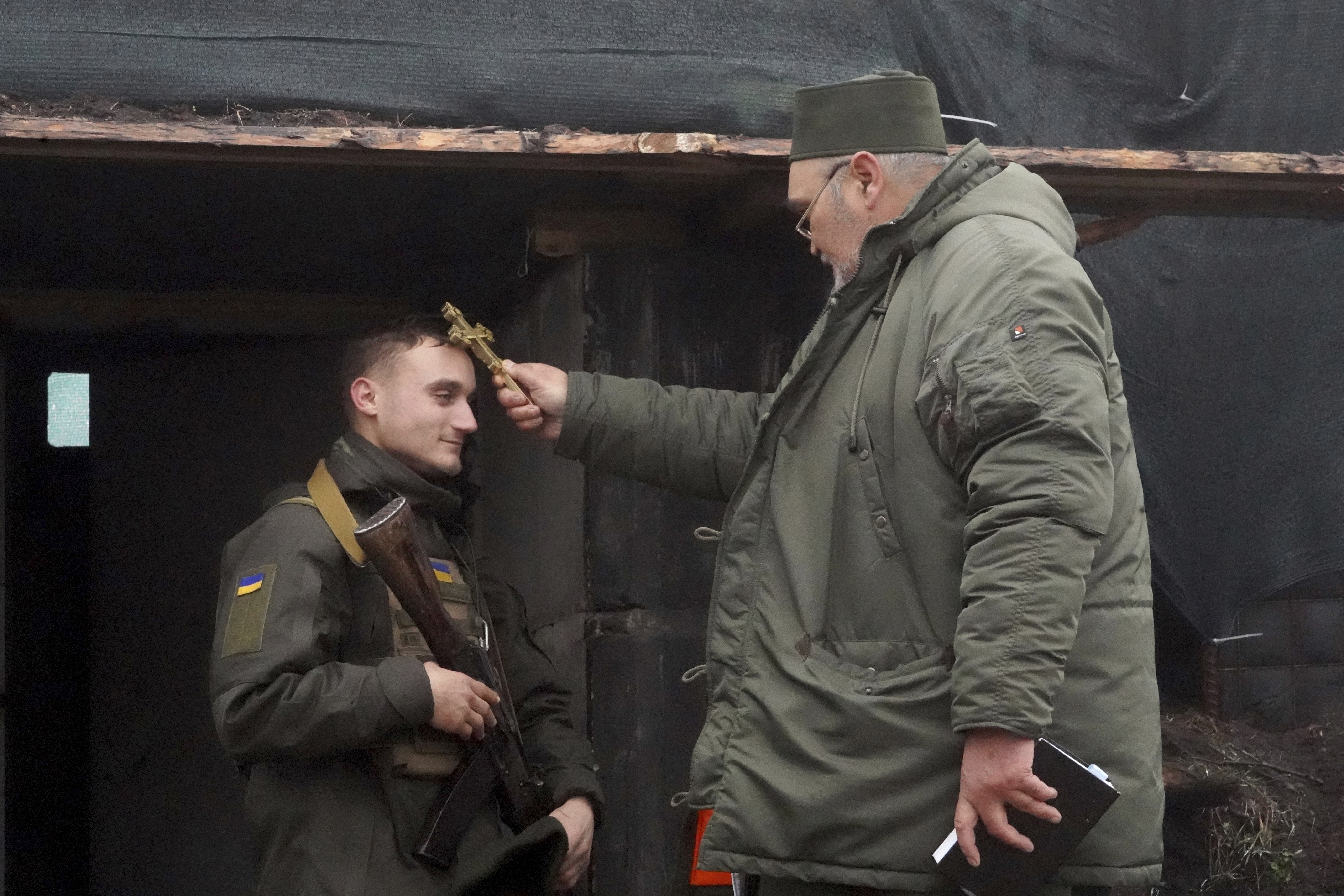 A chaplain blesses a soldier to mark Christmas at Ukraine's National Guard position close to the Russian border near Kharkiv, Ukraine, Saturday. 