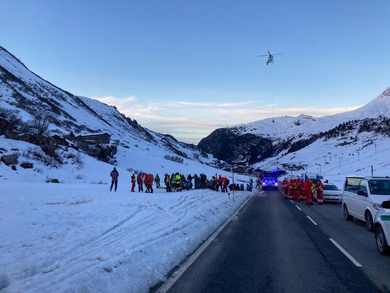 Rescue workers stand near the site where an avalanche buried 10 skiers in the Lech Zürs free skiing area on Arlberg, Austria, Sunday. 