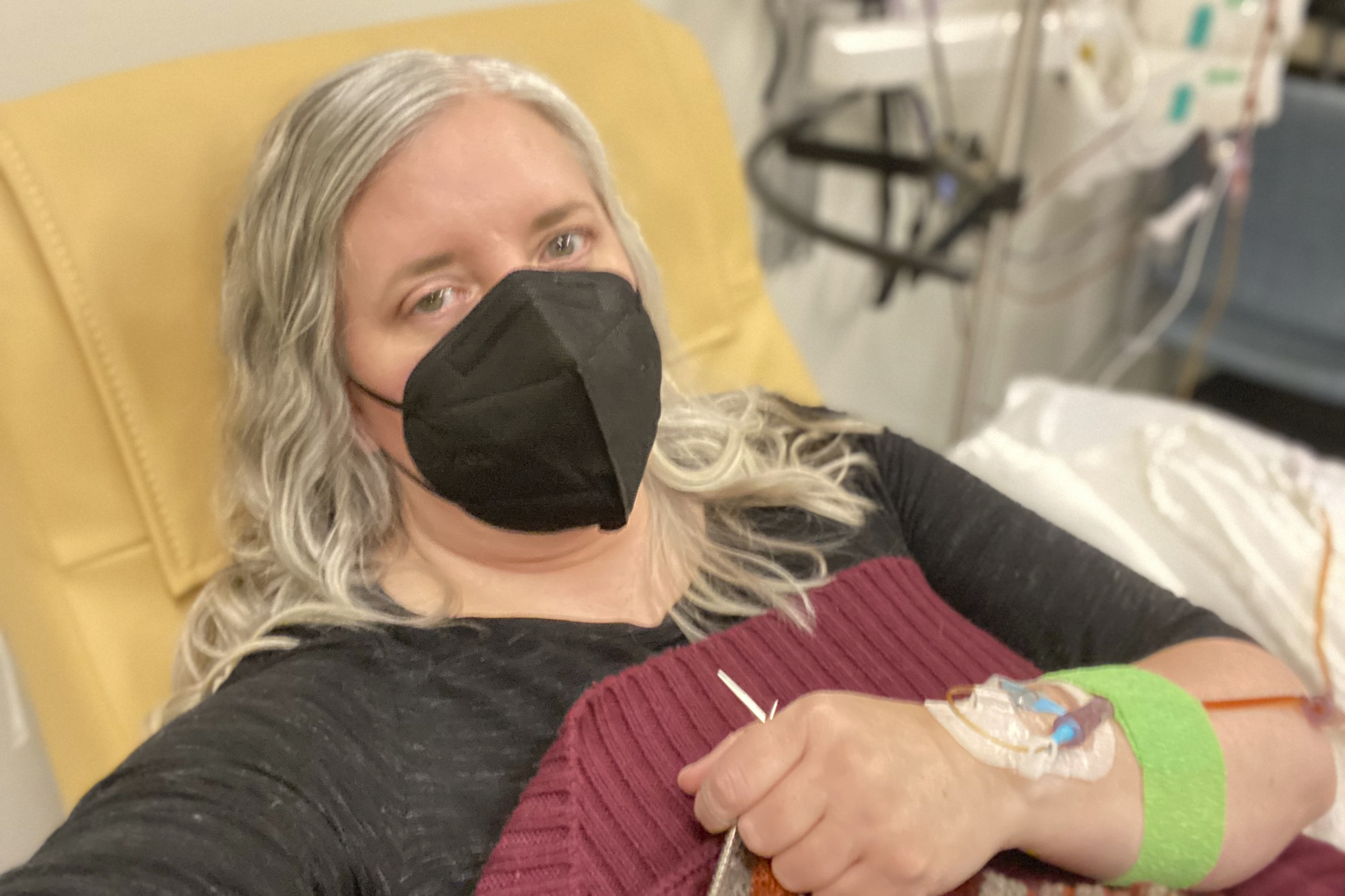 Amy Watson, of Portland, Ore., during an iron infusion in December 2022. Watson, approaching 50, says she has “never had any kind of recovery” from COVID-19. She has had severe migraines, plus digestive, nerve and foot problems. Recently she developed severe anemia. 