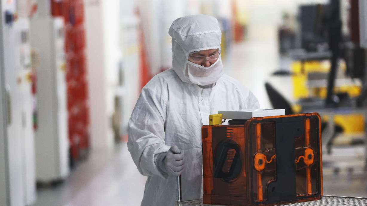 A worker moves wafers at Texas Instruments’ newly renovated microchip fabrication plant in Lehi on Dec. 14.