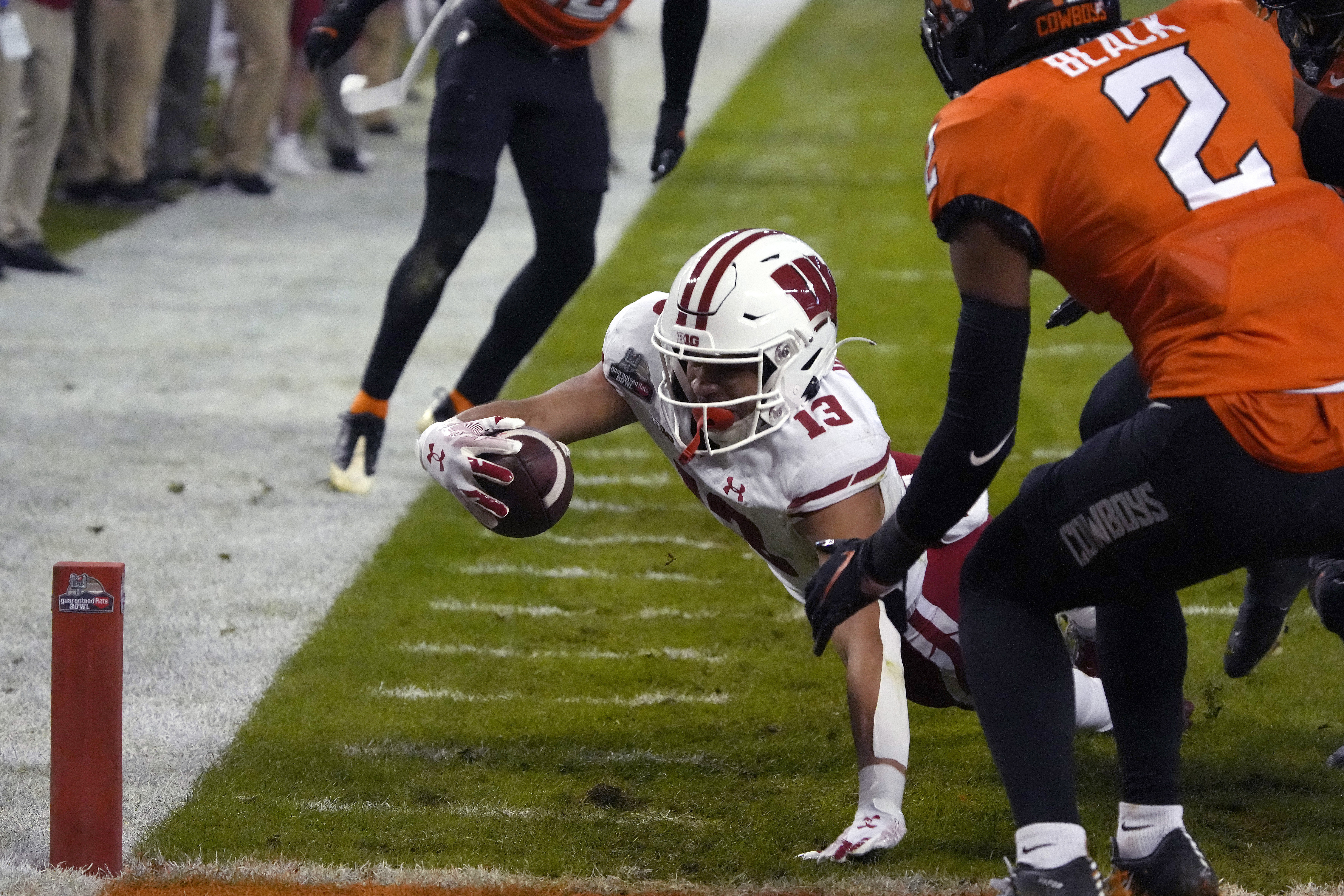 Wisconsin wide receiver Chimere Dike dives for the end zone in front of Oklahoma State cornerback Korie Black (2) during the first half of the Guaranteed Rate Bowl NCAA college football game Tuesday, Dec. 27, 2022, in Phoenix. 