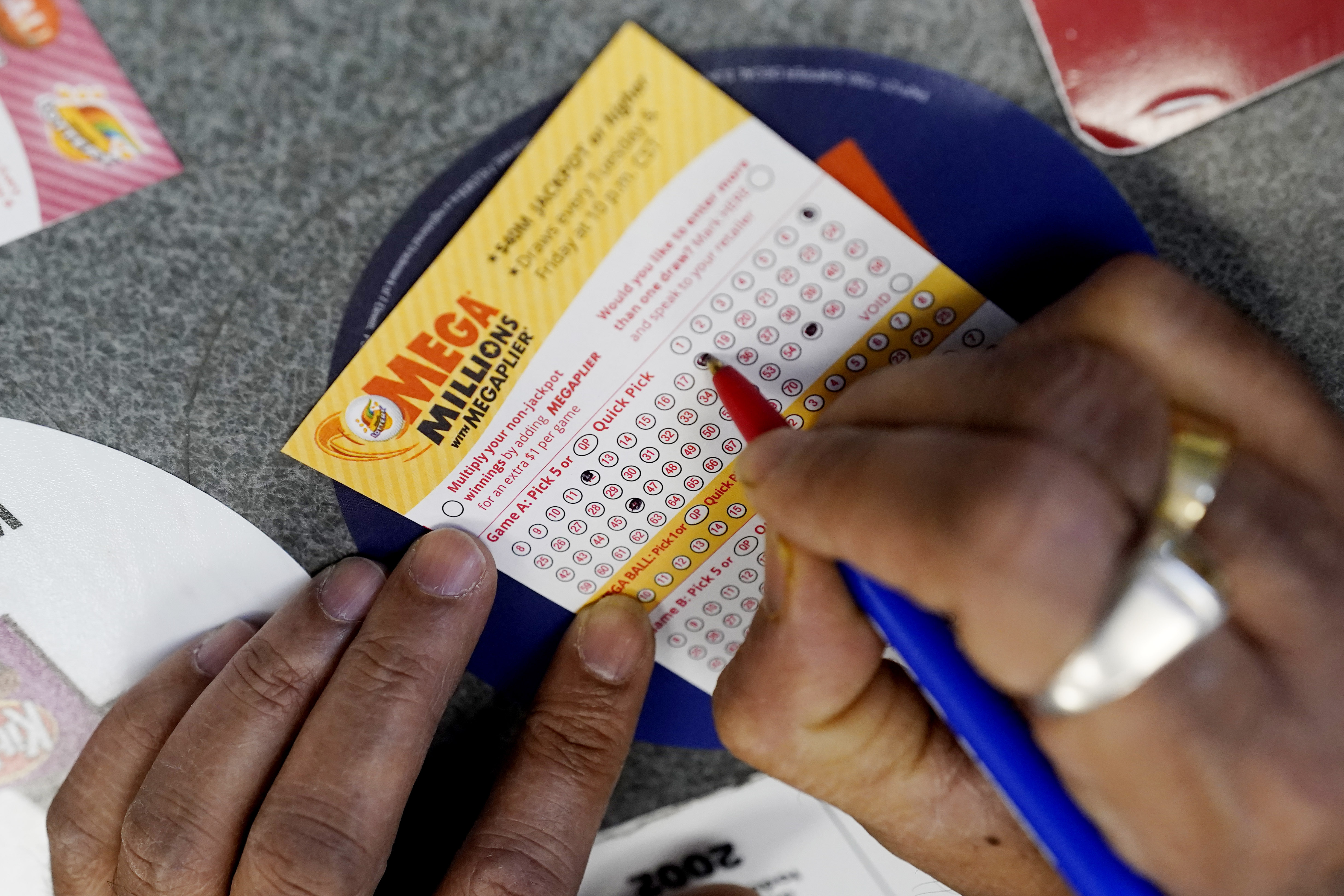 A customer fills out a Mega Millions lottery ticket in Northbrook, Ill., on Jan. 6, 2021. A giant Mega Millions jackpot grew to an estimated $640 million Wednesday after another drawing Tuesday without a winner. 