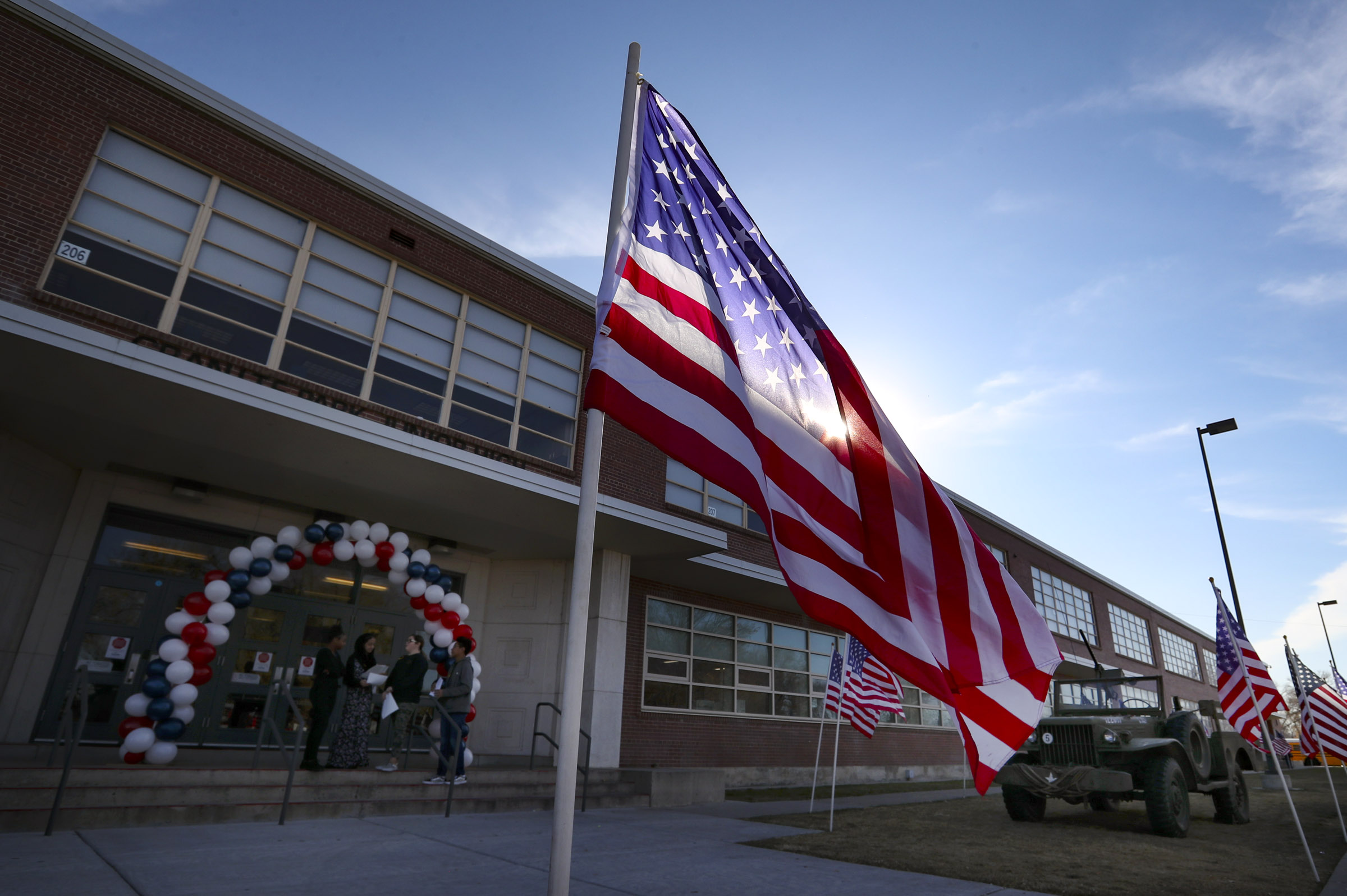 American flags wave at Granite Park Junior High School in South Salt Lake on Nov. 11, 2019. A staff member at the school was charged Wednesday with engaging in sexual activity with a 14-year-old student.