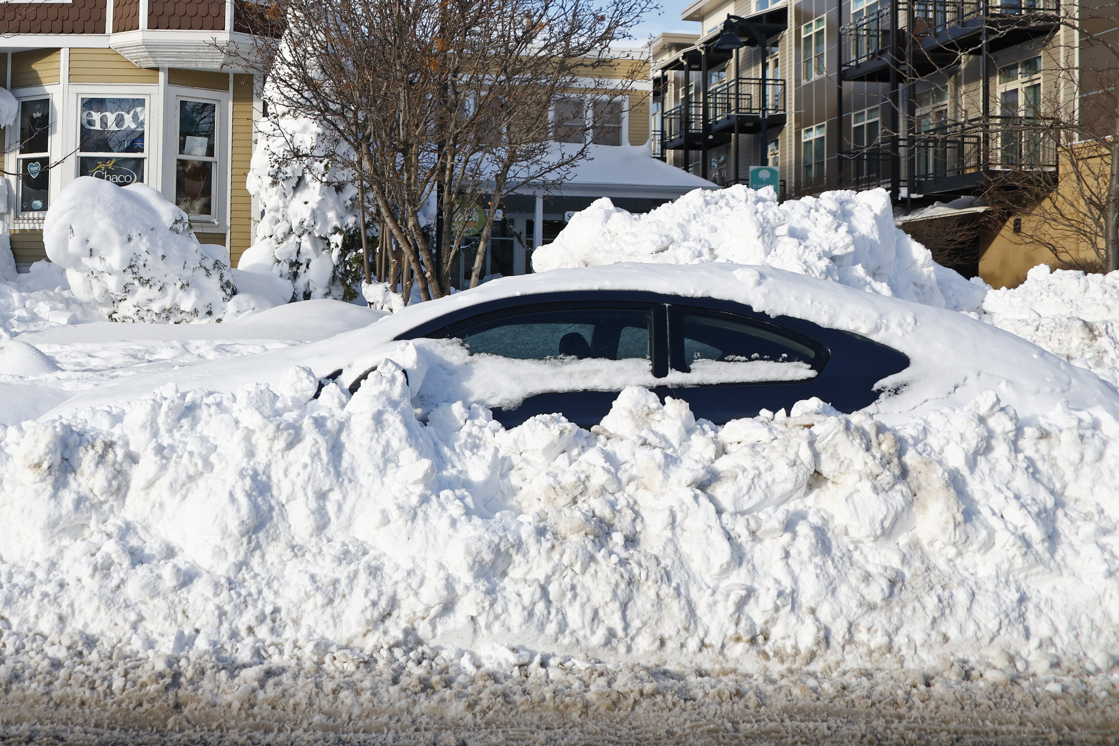 A car sits buried under snow, Wednesday, in Buffalo N.Y., following a winter storm.