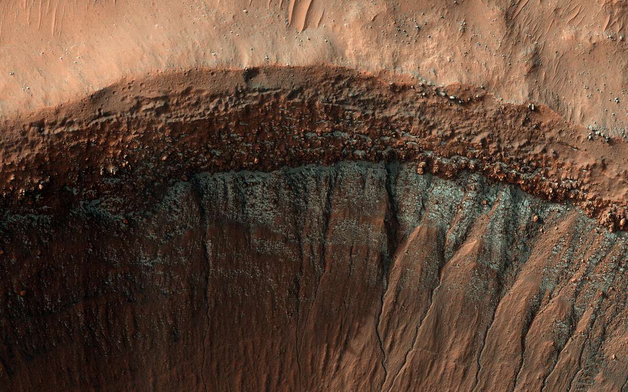 火星の南半球では、冬の間、斑状の二酸化炭素みぞれ、またはドライアイスがクレーター内に見られます。