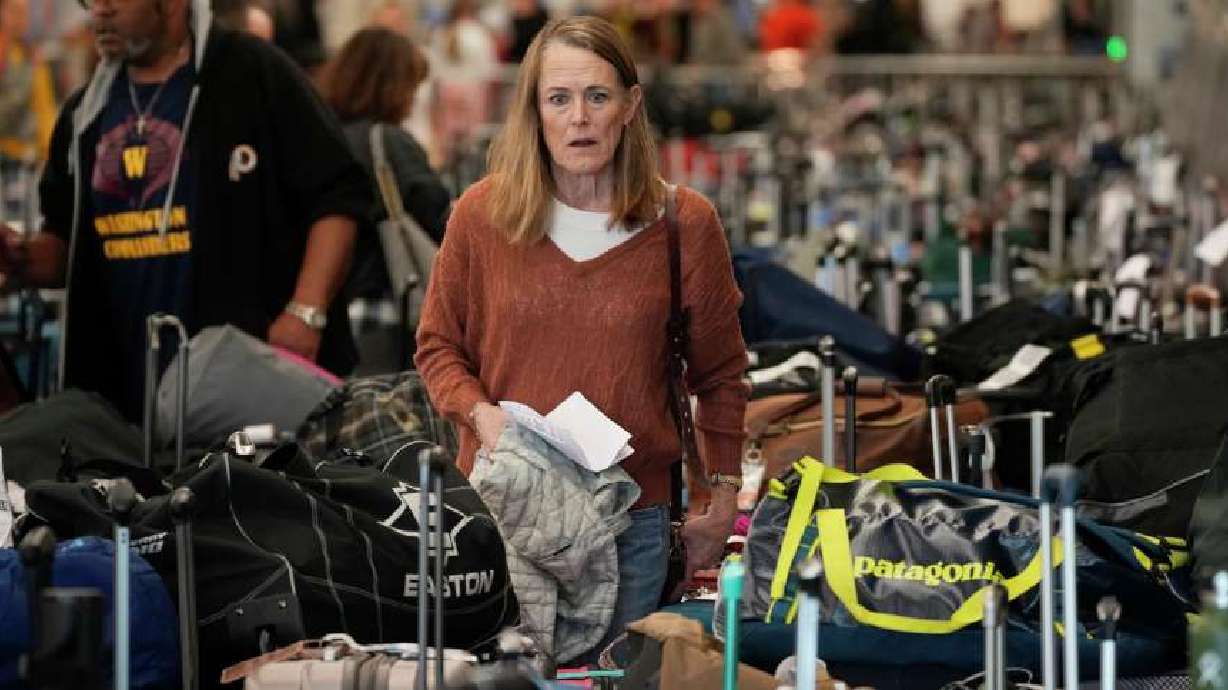 A traveler wades through the field of unclaimed bags at the Southwest Airlines luggage carousels at Denver International Airport on Tuesday.
