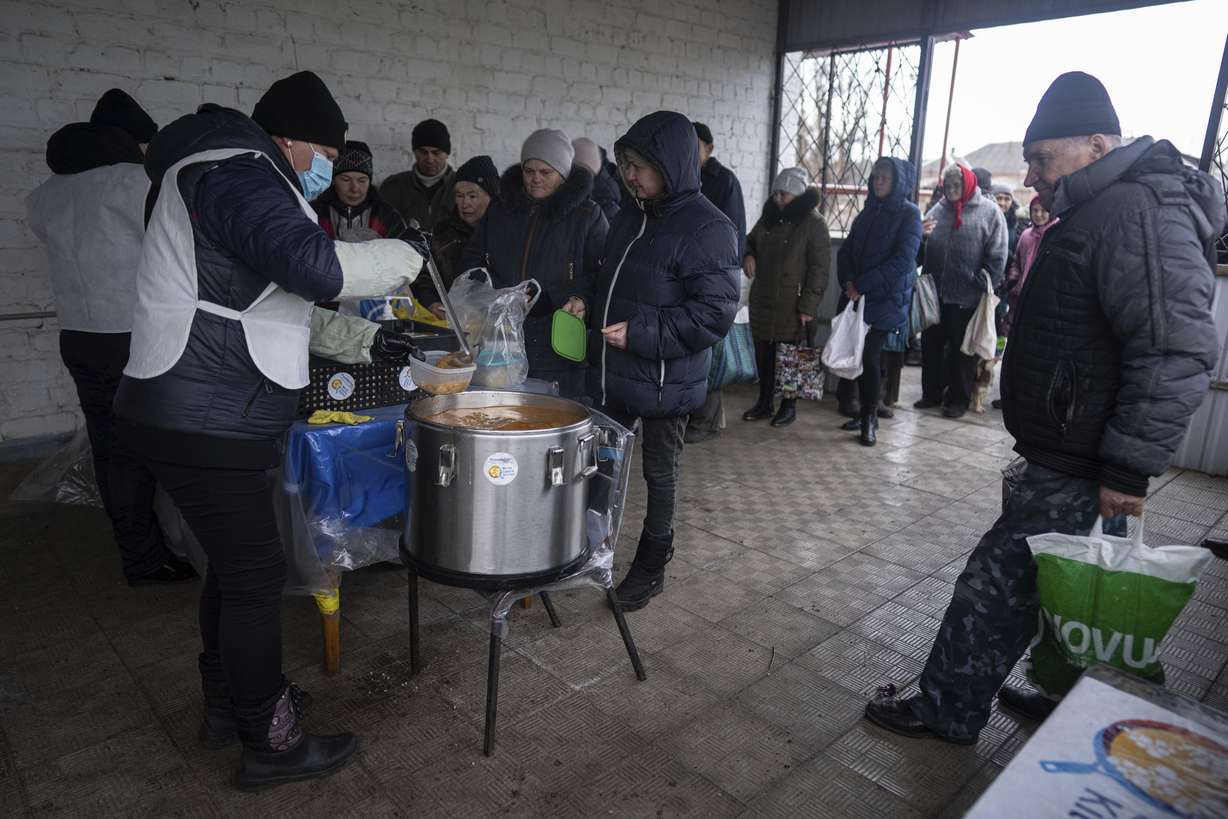 Local residents wait in line to receive a hot meal from volunteers of "World Central Kitchen" after living without electricity for more than four months in Kupiansk, Kharkiv region, Ukraine, Wednesday.