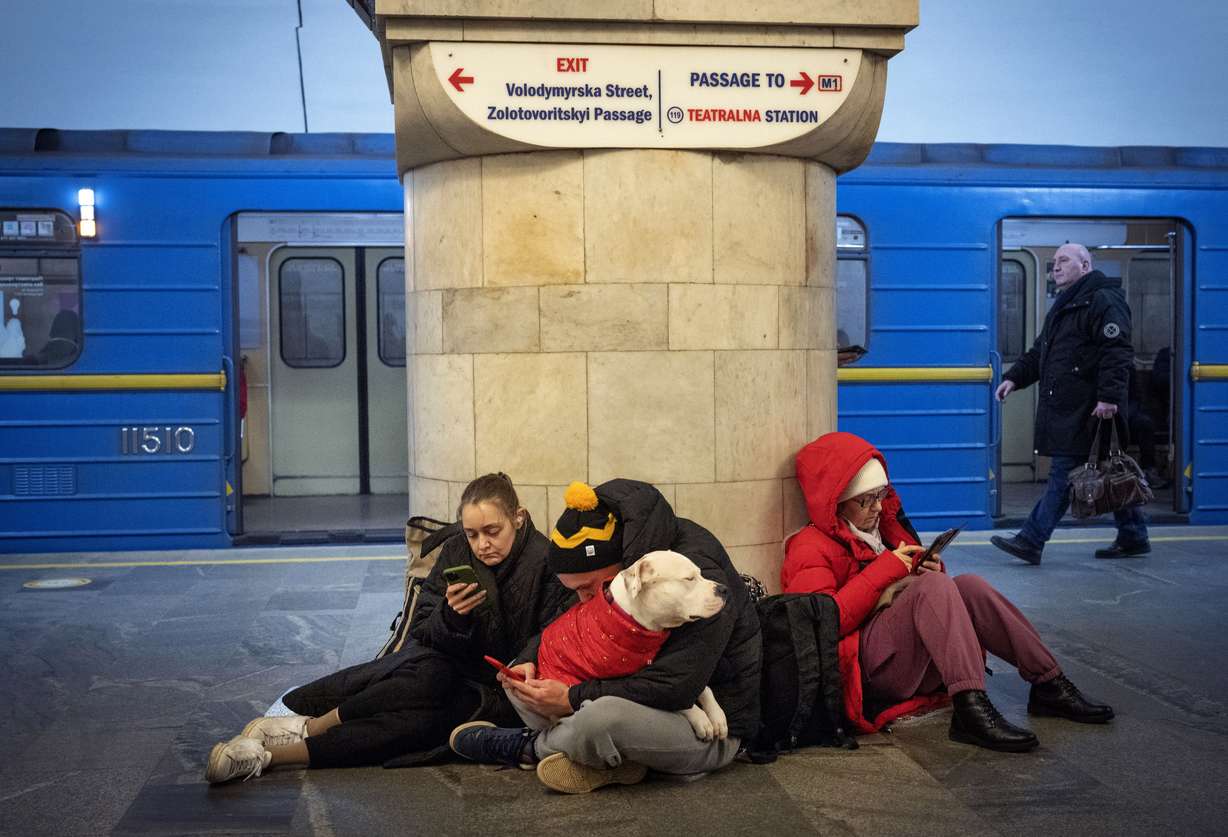 People sit in the subway station being used as a bomb shelter during a rocket attack in Kyiv, Ukraine, Thursday.