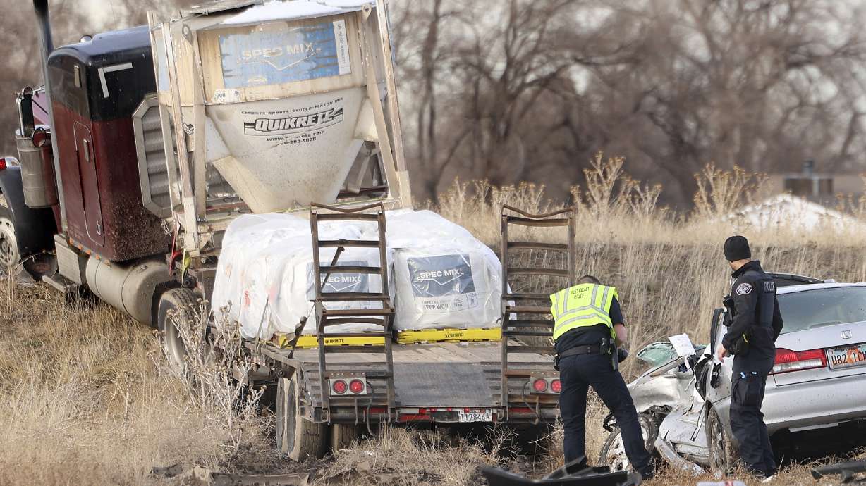 Law enforcement officials investigate a crash at 4100 South and Mountain View Corridor in West Valley City on Thursday. The crash involved three vehicles and one person was pronounced dead.