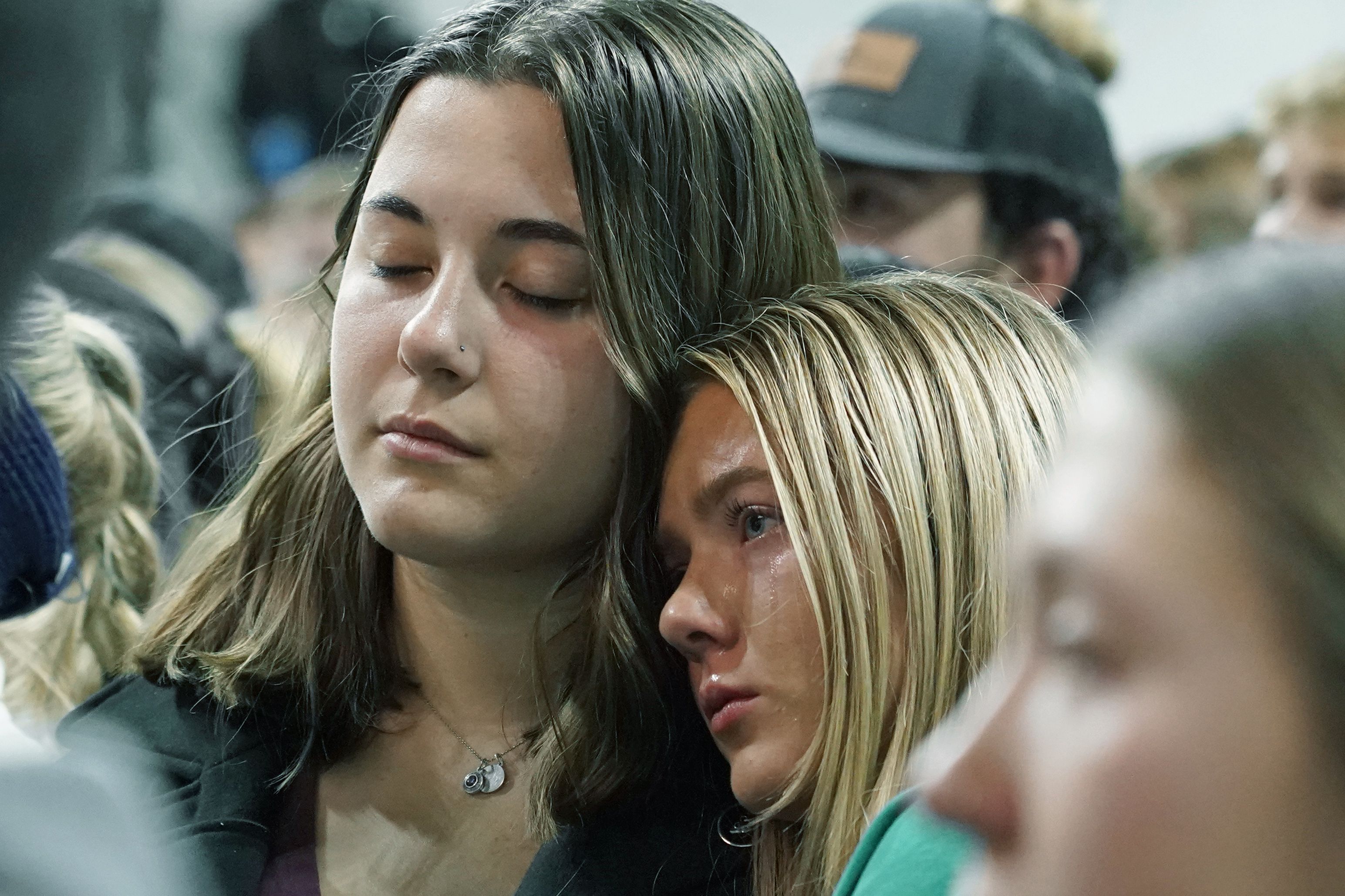 Two people attending a vigil for the four University of Idaho students who were killed on Nov. 13 lean against each other as they listen to family members talk about the victims on Wednesday, Nov. 30 in Moscow, Idaho.