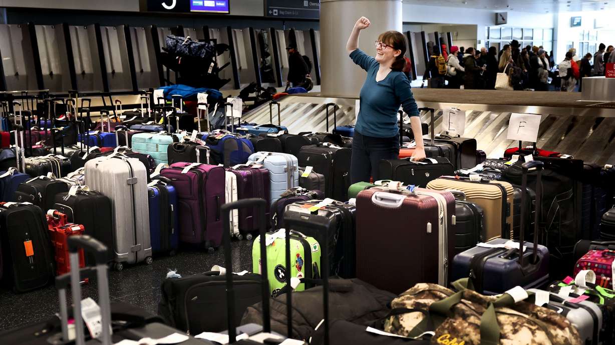 Casandra Friend, of Provo, celebrates after finding her luggage at the Southwest Airlines luggage carousel at the Salt Lake City International Airport in Salt Lake City on Friday.
