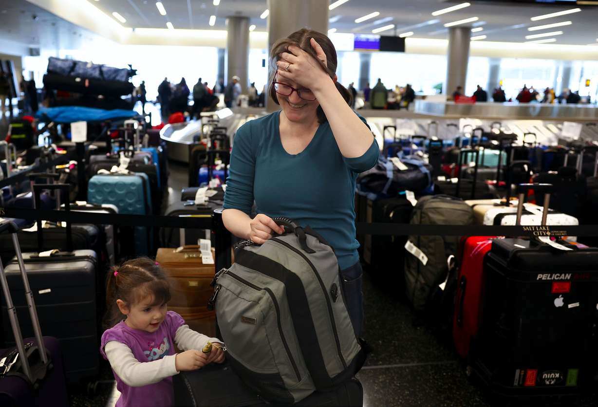 Casandra Friend, of Provo, laughs as her daughter asks for a toy after collecting their luggage at the Southwest luggage carousel at the Salt Lake City International Airport in Salt Lake City on Friday.