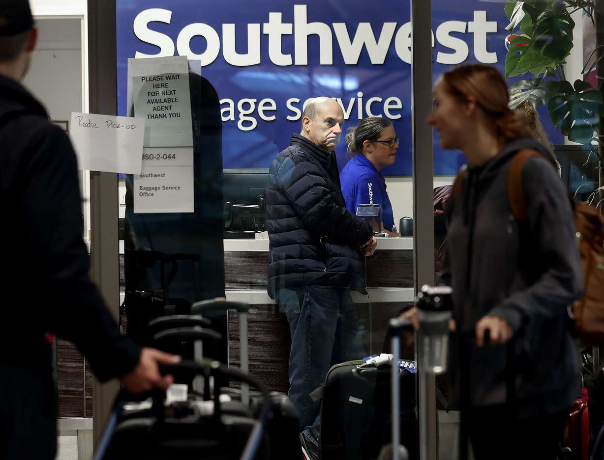 Customers gather at the Southwest Airlines customer service office at the Salt Lake City International Airport in Salt Lake City on Friday.