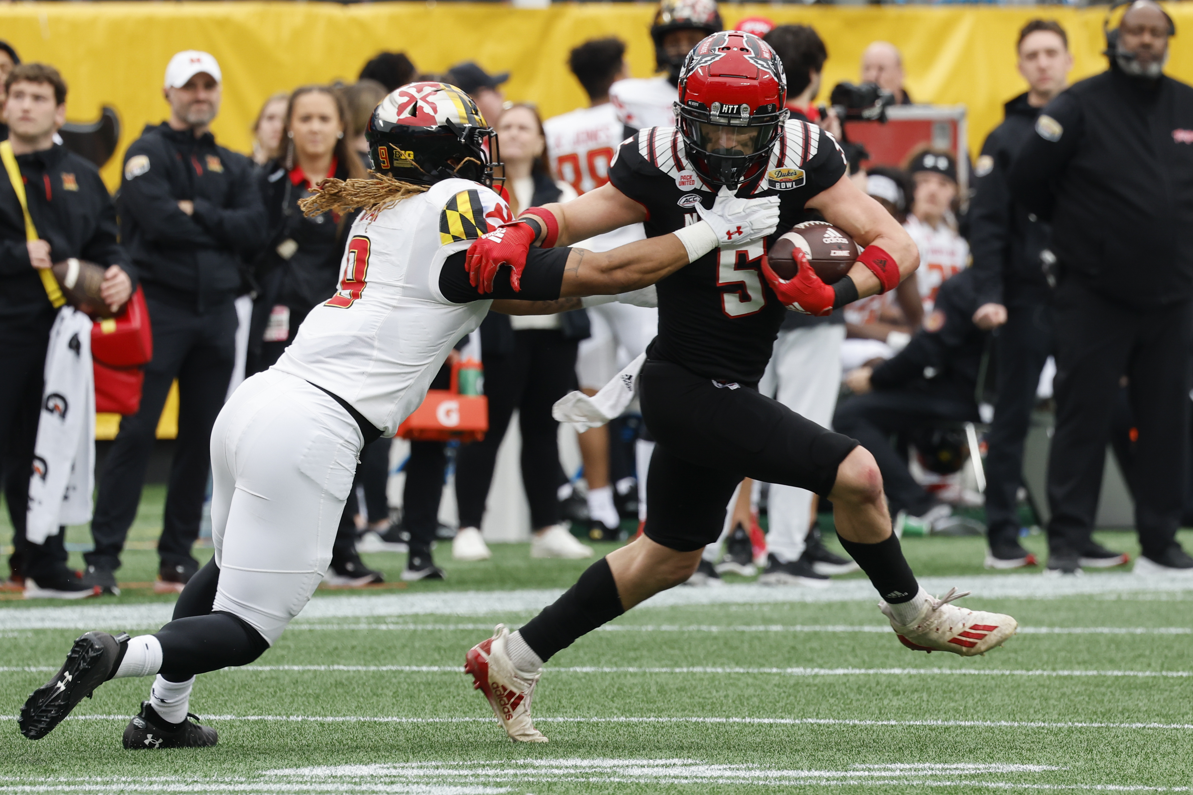 North Carolina State wide receiver Thayer Thomas, right, fights for yardage after a catch as Maryland linebacker Fa'Najae Gotay reaches in during the first half of the Duke's Mayo Bowl NCAA college football game in Charlotte, N.C., Friday, Dec. 30, 2022. 