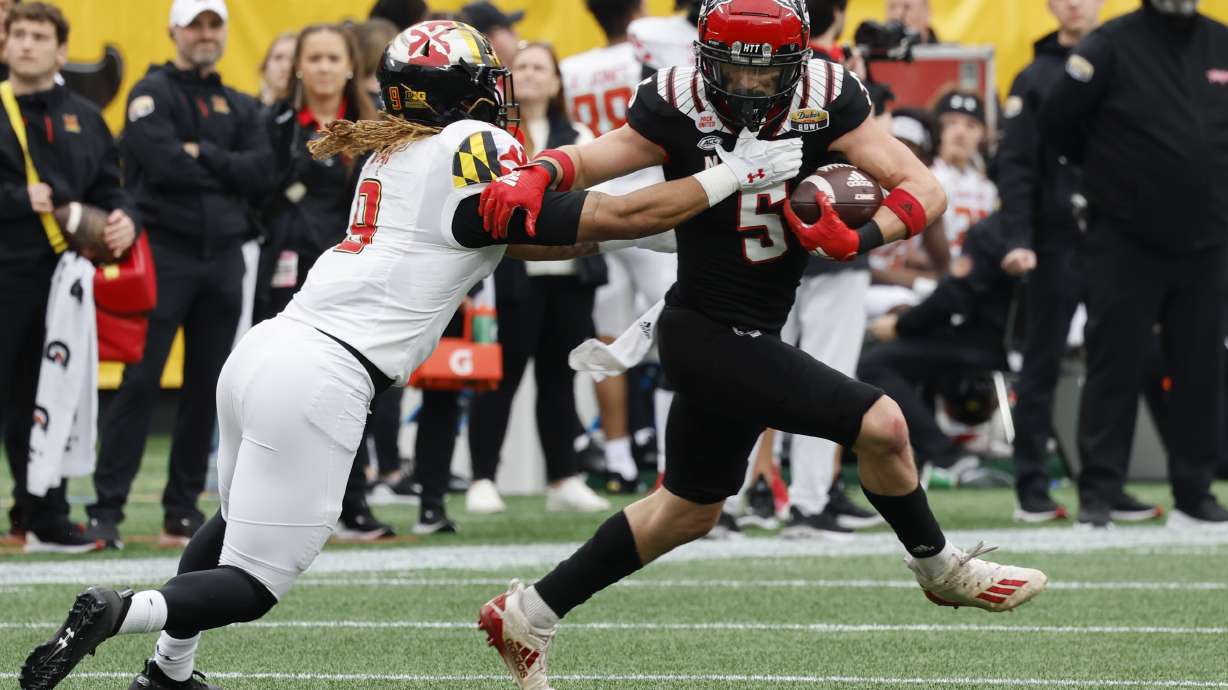 North Carolina State wide receiver Thayer Thomas, right, fights for yardage after a catch as Maryland linebacker Fa'Najae Gotay reaches in during the first half of the Duke's Mayo Bowl NCAA college football game in Charlotte, N.C., Friday, Dec. 30, 2022.