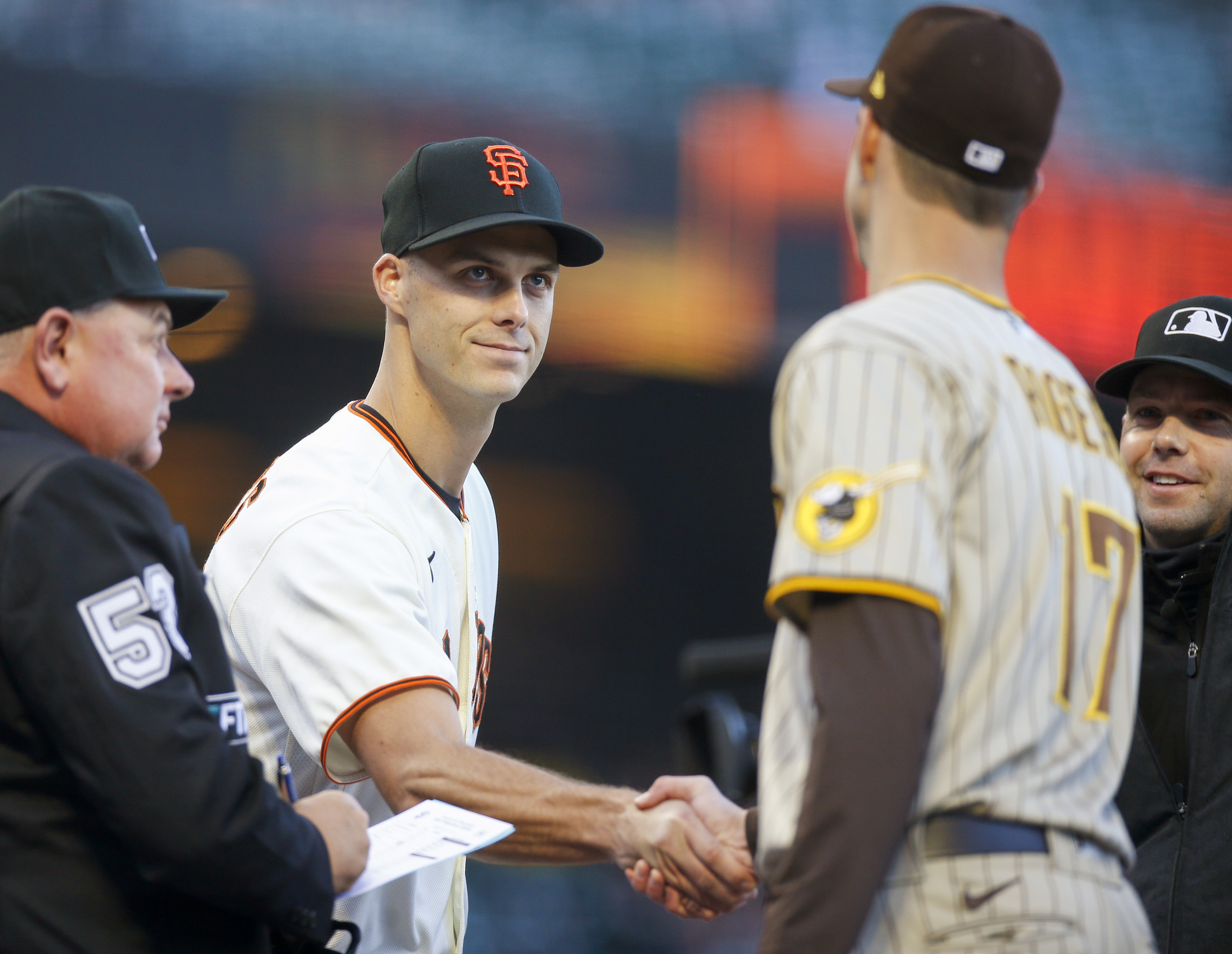 FILE - San Francisco Giants' Tyler Rogers, left, shakes hands with his brother San Diego Padres' Taylor Rogers (17) as they exchange lineups before their game in San Francisco, on Monday, April 11, 2022. Left-hander Taylor Rogers is joining twin brother Tyler as a reliever with the San Francisco Giants, agreeing to a $33 million, three-year contract, Wednesday, Dec. 28, 2022.