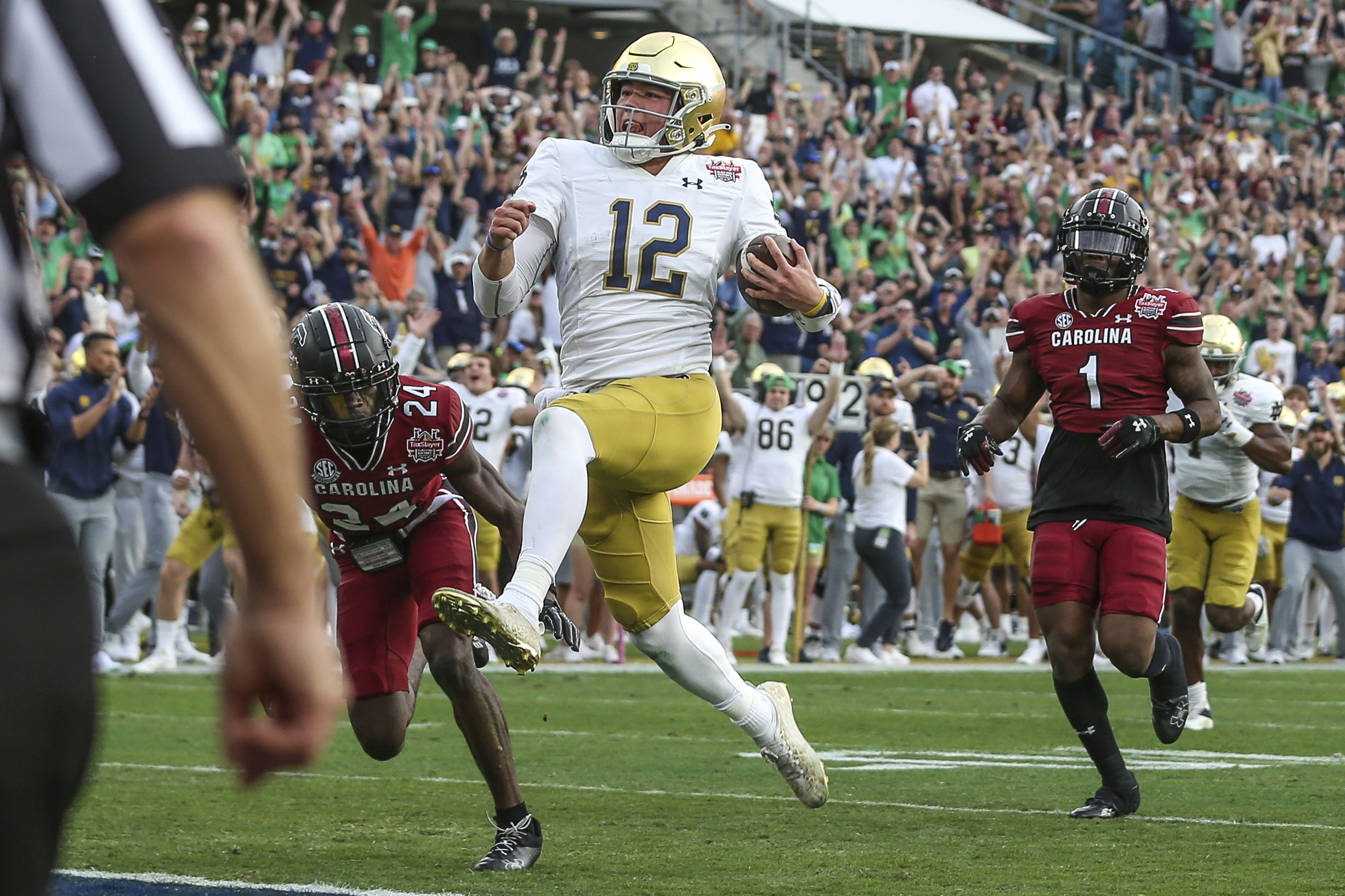 Notre Dame quarterback Tyler Buchner (12) crosses into the end zone for a touchdown during the first quarter of the Gator Bowl NCAA college football game against South Carolina on Friday, Dec. 30, 2022, in Jacksonville, Fla. 
