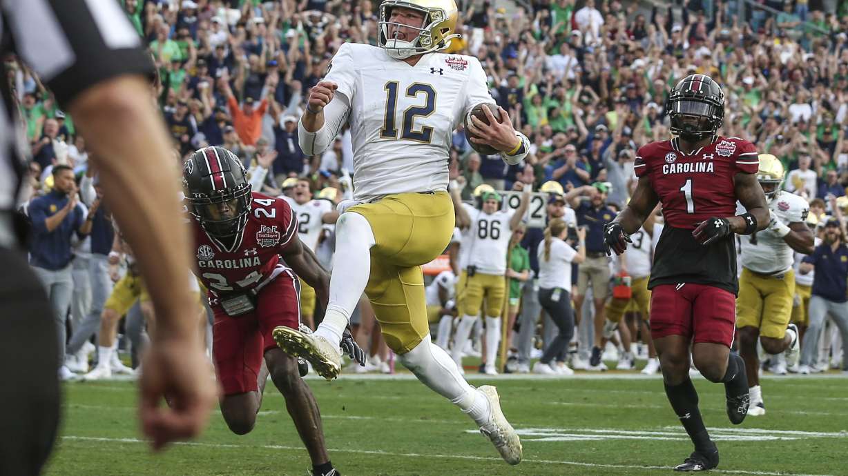 Notre Dame quarterback Tyler Buchner (12) crosses into the end zone for a touchdown during the first quarter of the Gator Bowl NCAA college football game against South Carolina on Friday, Dec. 30, 2022, in Jacksonville, Fla.