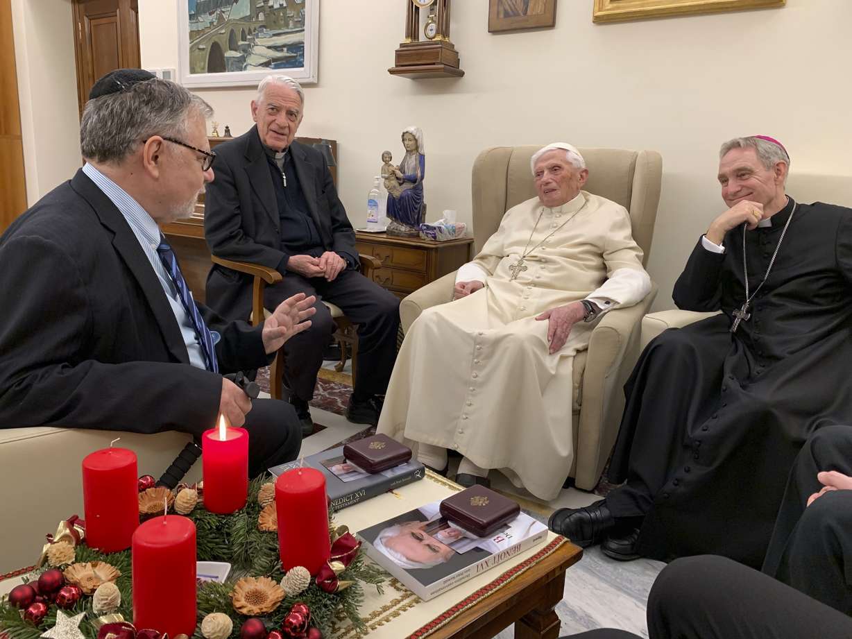 Pope Emeritus Benedict XVI, third from left, meets with the winners of the 2022 Ratzinger Prize, Joseph Halevi Horowitz Weiler, left, and father Michel Fedou, partially hidden at right, at the Mater Ecclesiae monastery inside the Vatican where Benedict XVI lives, in this photo taken Thursday. Second from left, is the foundation's president Father Federico Lombardi, and fourth from left is Benedict XVI's long-time personal secretary Bishop Georg Gänswein.