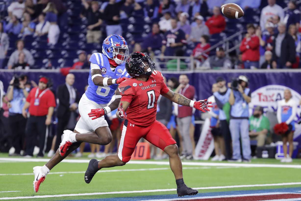Texas Tech running back Cam'Ron Valdez (0) watches the ball fly away after it was popped out of his grip by Mississippi cornerback Miles Battle, left, as they entered the end zone during the second half of the Texas Bowl NCAA college football game Wednesday Dec. 28, 2022, in Houston.