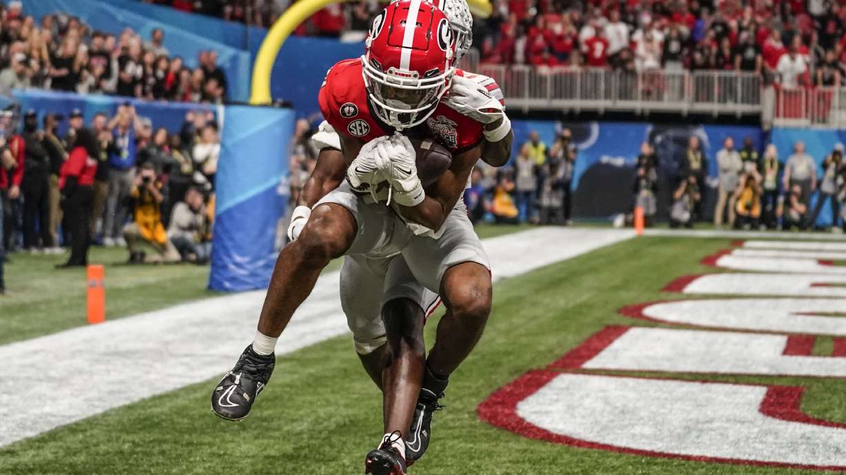 Georgia wide receiver Adonai Mitchell (5) makes a touchdown catch against Ohio State cornerback Denzel Burke (10) during the second half of the Peach Bowl NCAA college football semifinal playoff game, Saturday, Dec. 31, 2022, in Atlanta.