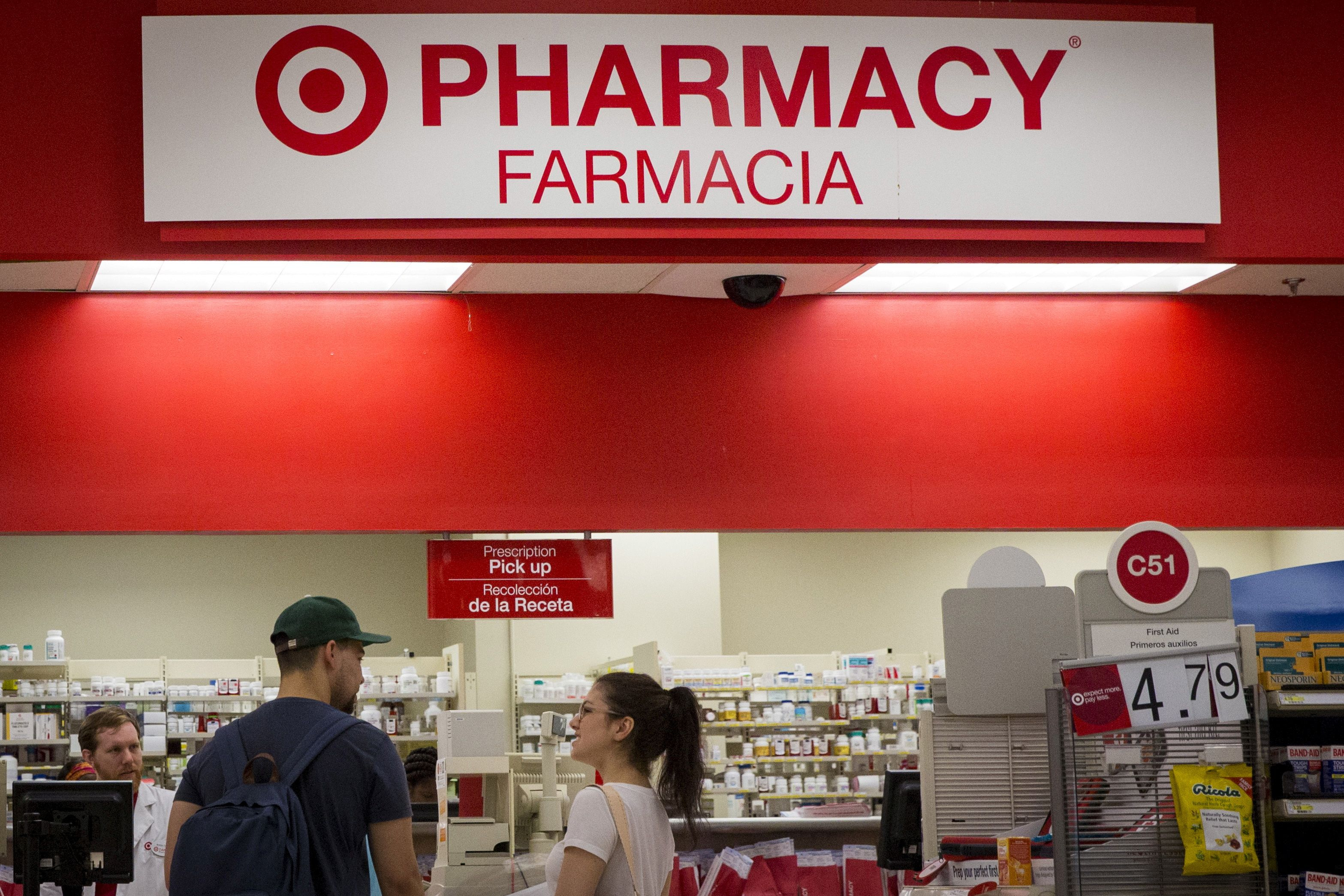 Customers wait in the pharmacy department at a Target store in the Brooklyn borough of New York June 15, 2015. Several drugmakers plan to raise prices in the United States on more than 350 unique drugs in early January, according to an analysis.