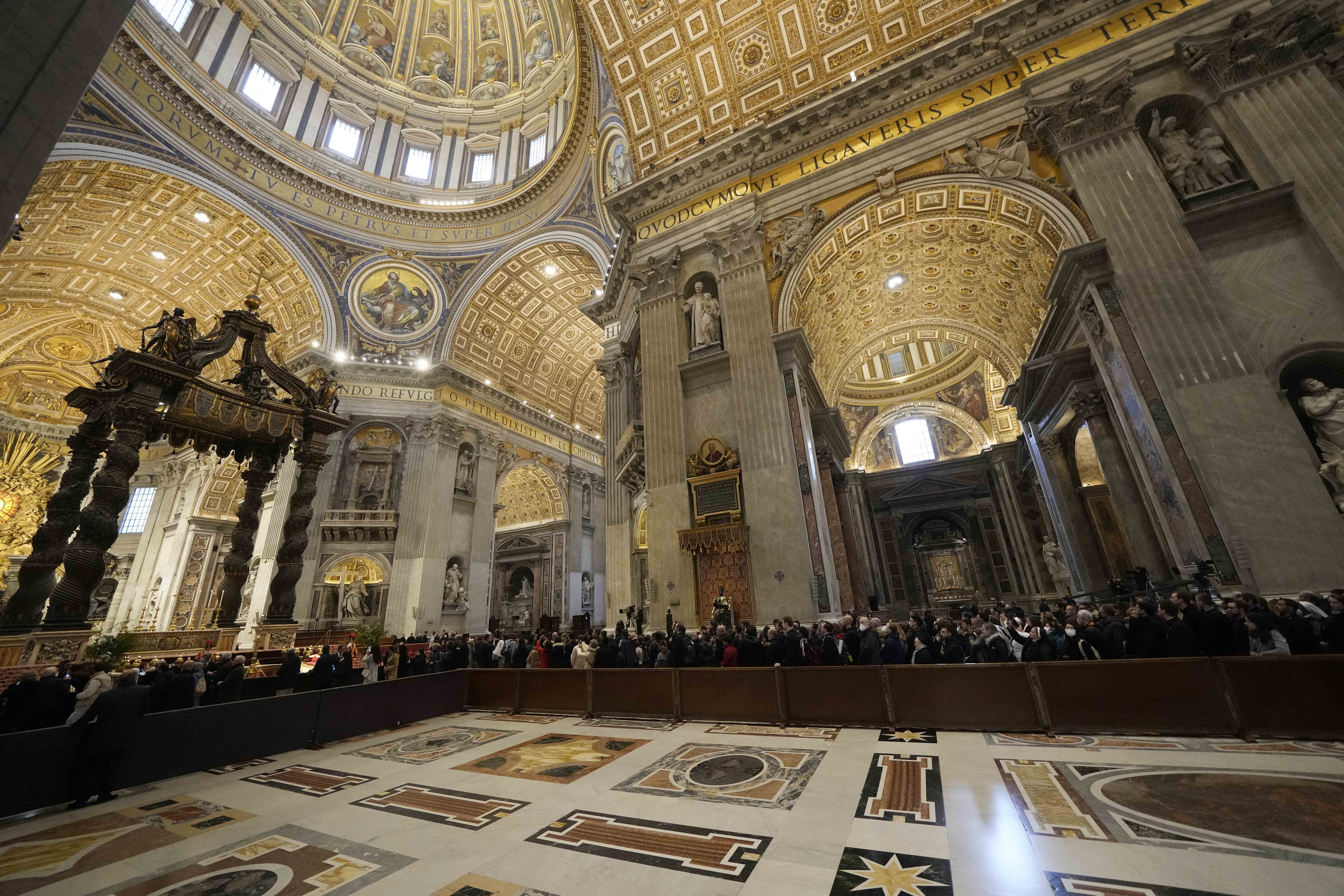 People look at the body of late Pope Emeritus Benedict XVI inside St. Peter's Basilica at The Vatican, Monday. Benedict XVI died at age 95.