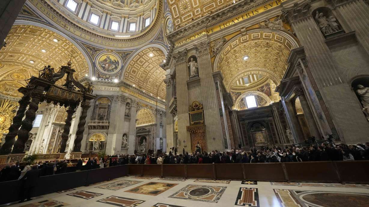 People look at the body of late Pope Emeritus Benedict XVI inside St. Peter's Basilica at The Vatican, Monday. Benedict XVI died at age 95.