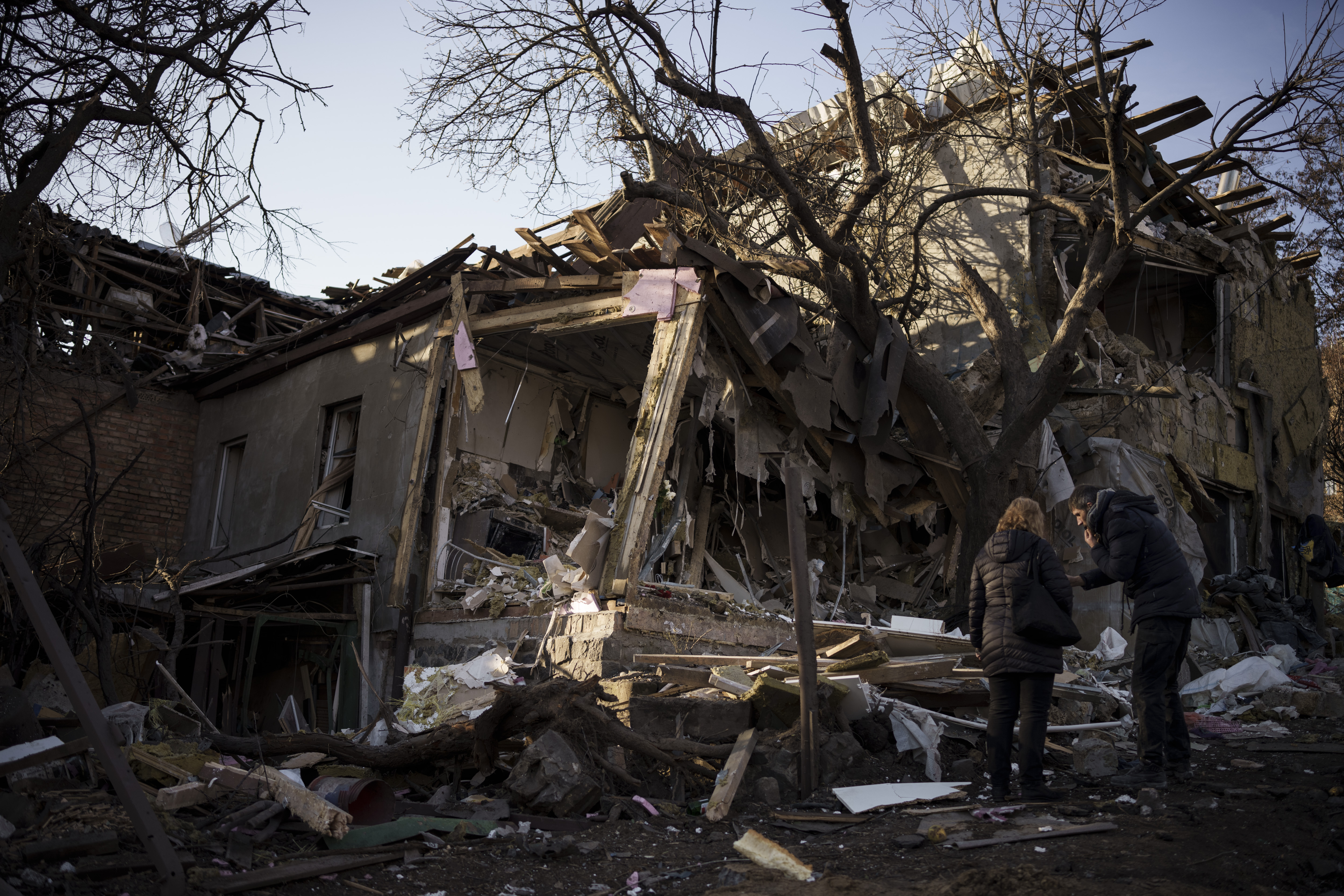 Serhii Kaharlytskyi, right, stands outside his home, destroyed after a Russian attack in Kyiv, Ukraine, Monday. Kaharlytskyi's wife Iryna died in the attack on Saturday.