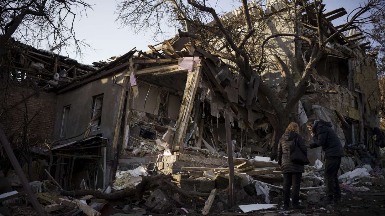 Serhii Kaharlytskyi, right, stands outside his home, destroyed after a Russian attack in Kyiv, Ukraine, Monday. Kaharlytskyi's wife Iryna died in the attack on Saturday.