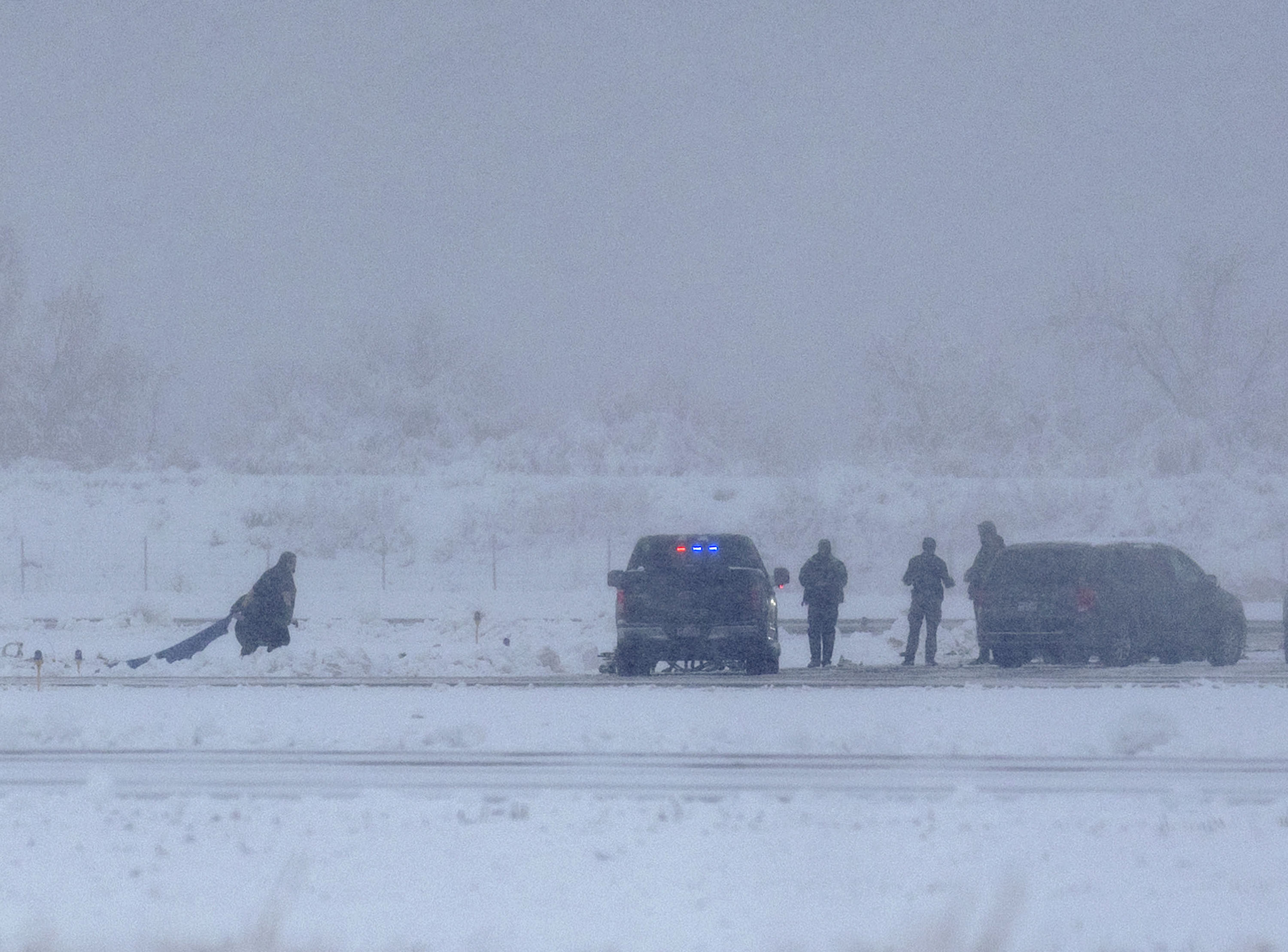 Law enforcement officials investigate the scene of a Provo Airport-based aircraft with four people on board that crashed immediately after takeoff at the Provo Airport on Monday.