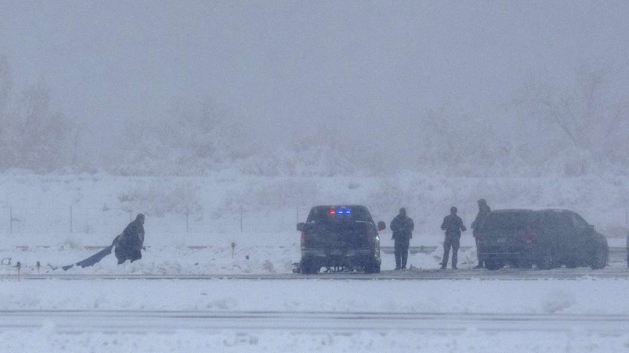 Law enforcement officials investigate the scene of a Provo Airport-based aircraft with four people on board that crashed immediately after takeoff at the Provo Airport on Monday.