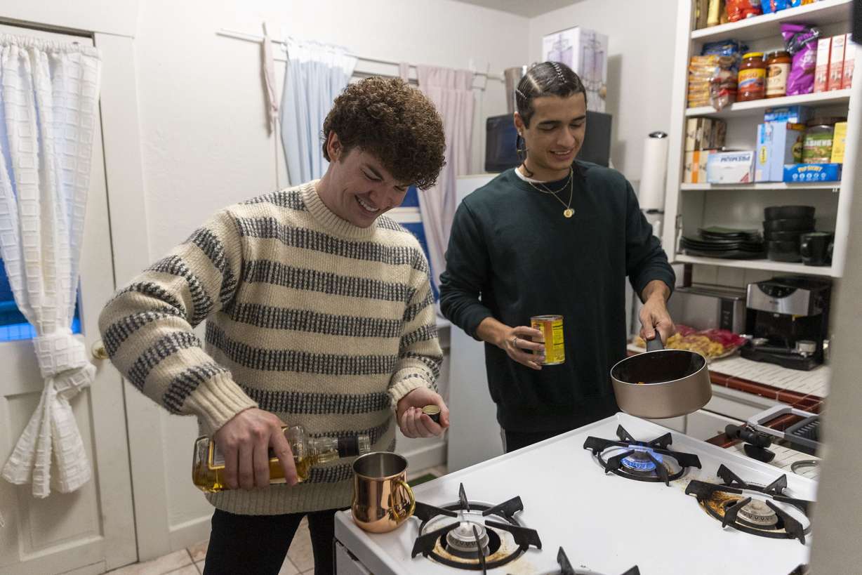 Joseph Branca, left, makes a drink while his partner Scotty Fletcher makes dinner at their apartment they rent in Salt Lake City on Thursday.
