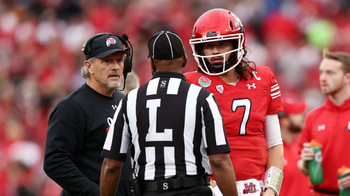 Utah Utes head coach Kyle Whittingham and Utah Utes QB Cameron Rising (7) listen to a official as Utah and Penn State play in the Rose Bowl in Pasadena, California, on Monday, Jan. 2, 2023.