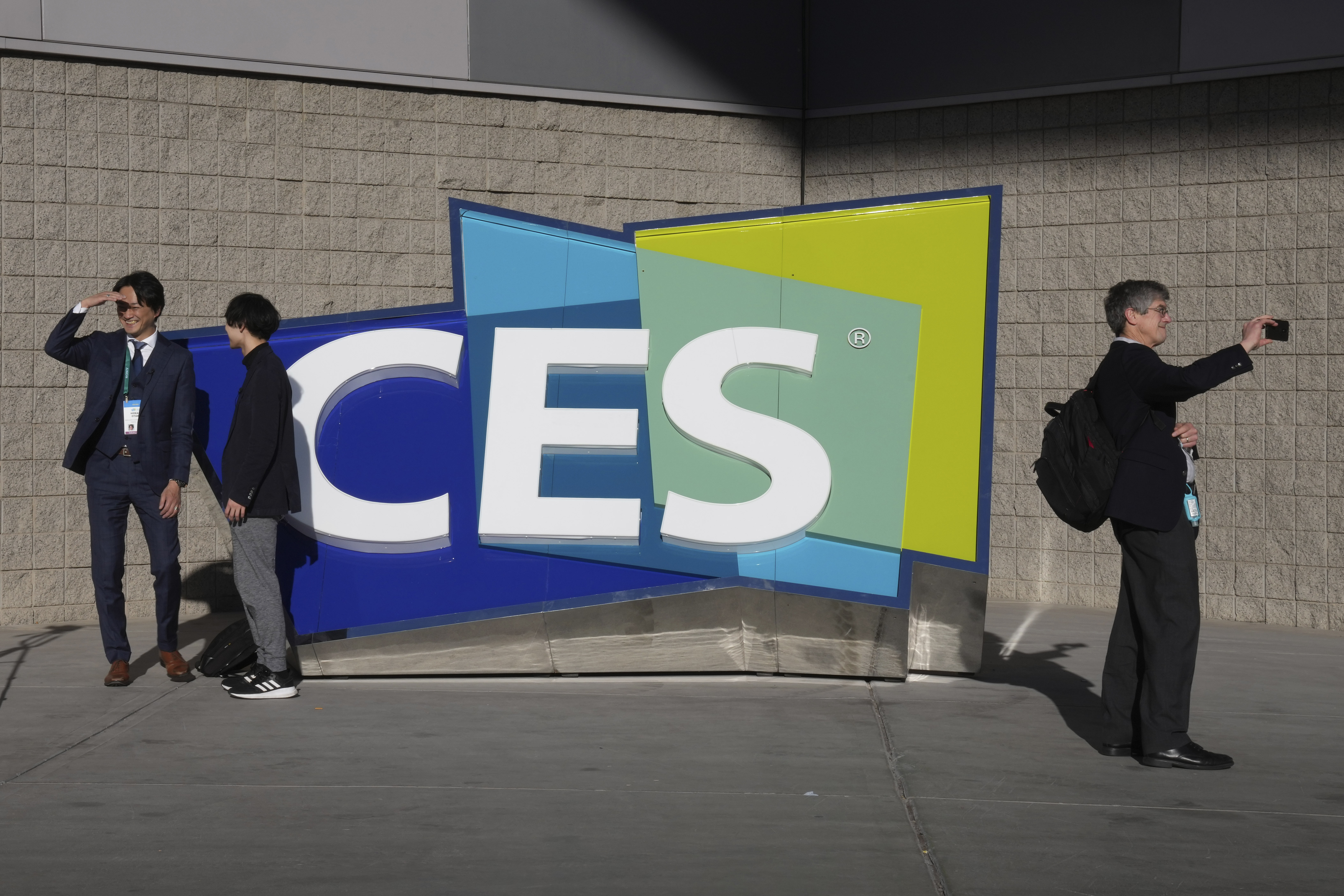 People take pictures in front of a sign during the CES tech show on Jan. 6 in Las Vegas. CES is returning to Las Vegas in January 2023 with the hope that it inches closer to how it looked before the pandemic. 