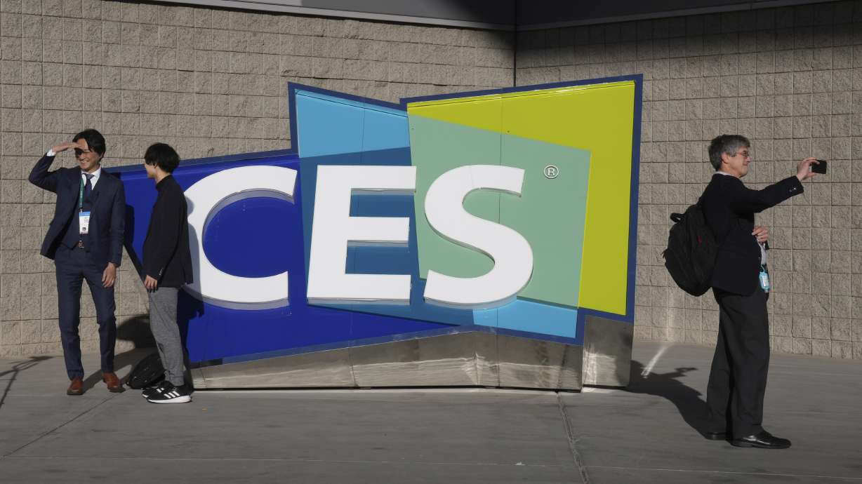 People take pictures in front of a sign during the CES tech show on Jan. 6 in Las Vegas. CES is returning to Las Vegas in January 2023 with the hope that it inches closer to how it looked before the pandemic.