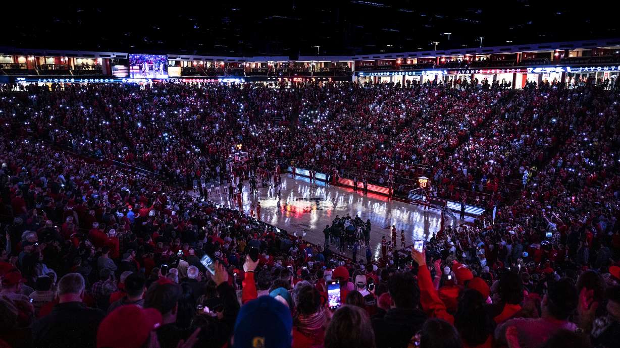 Fans light up the stands with cell phone flashlights during the first half an NCAA college basketball game between Colorado State and New Mexico in Albuquerque, N.M., Wednesday, Dec. 28, 2022.
