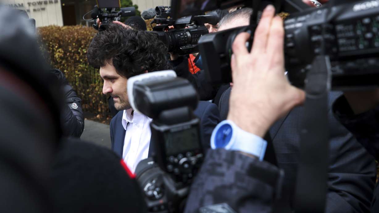 FTX founder Sam Bankman-Fried, center, is escorted to his car from the U.S. District Court in Manhattan, Dec. 22, 2022, in New York. A judge agreed to a request by prosecutors to keep it secret that two of Bankman-Fried's executive associates had turned against him so that the cryptocurrency entrepreneur would agree not to fight extradition from the Bahamas to the United States, according to transcripts of plea deals made public Dec. 23, 2022.