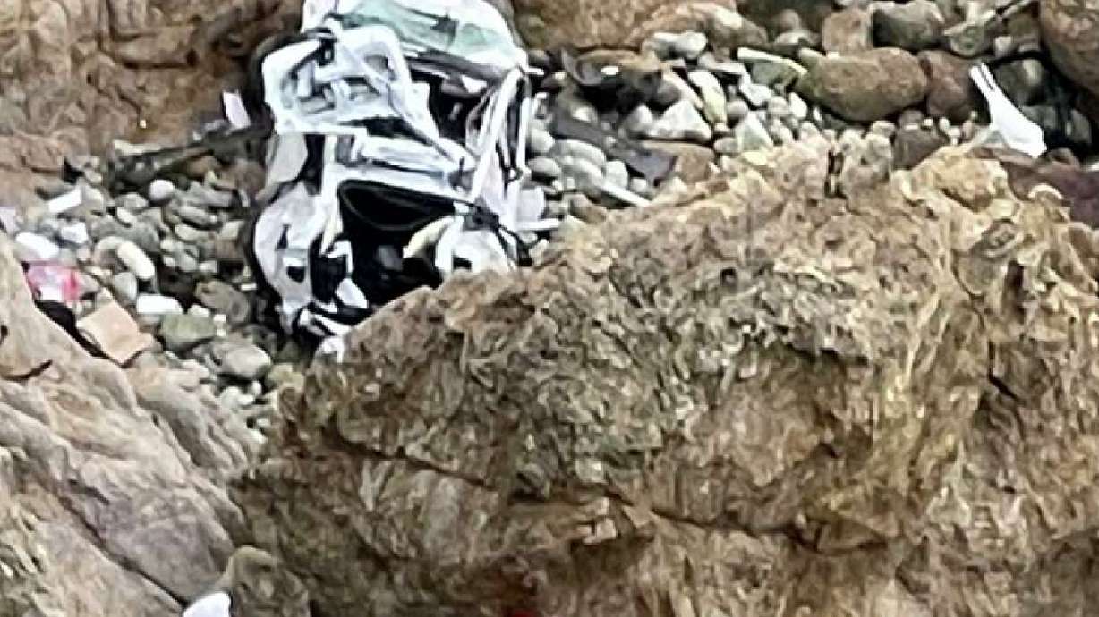 This image from video shows a Tesla vehicle that plunged off a Northern California cliff along the Pacific Coast Highway, Monday near an area known as Devil's Slide, leaving four people in critical condition, a fire official said. The vehicle fell about 250 feet from the highway.