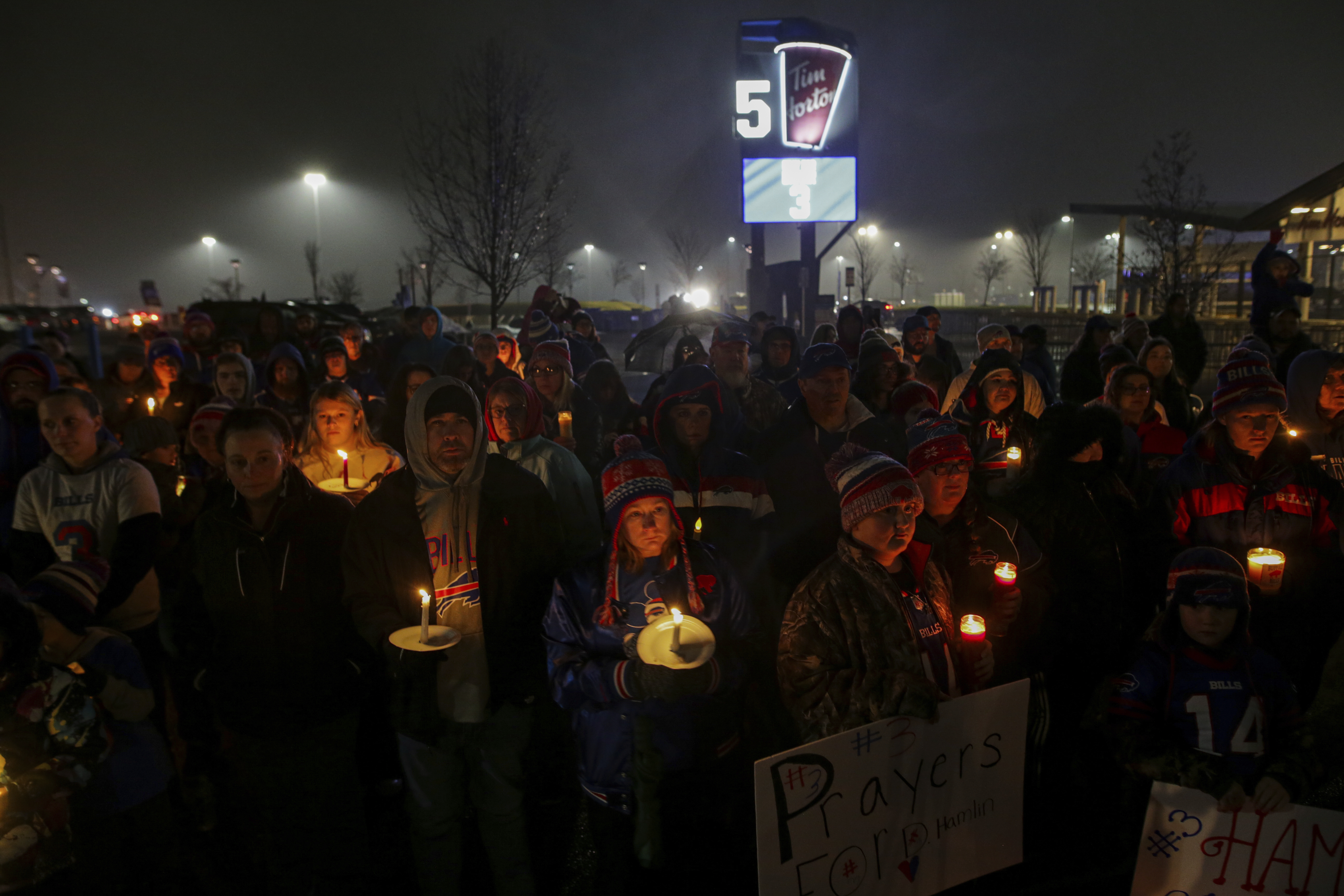 FILE - Buffalo Bills fans and community members gather for a candlelight vigil for Buffalo Bills safety Damar Hamlin on Tuesday, Jan. 3, 2023, in Orchard Park, N.Y. The Buffalo Bills have been a reliable bright spot for a city that has been shaken by a racist mass shooting and back-to-back snowstorms in recent months. So when Bills safety Damar Hamlin was critically hurt in a game Monday, the city quickly looked for ways to support the team. 