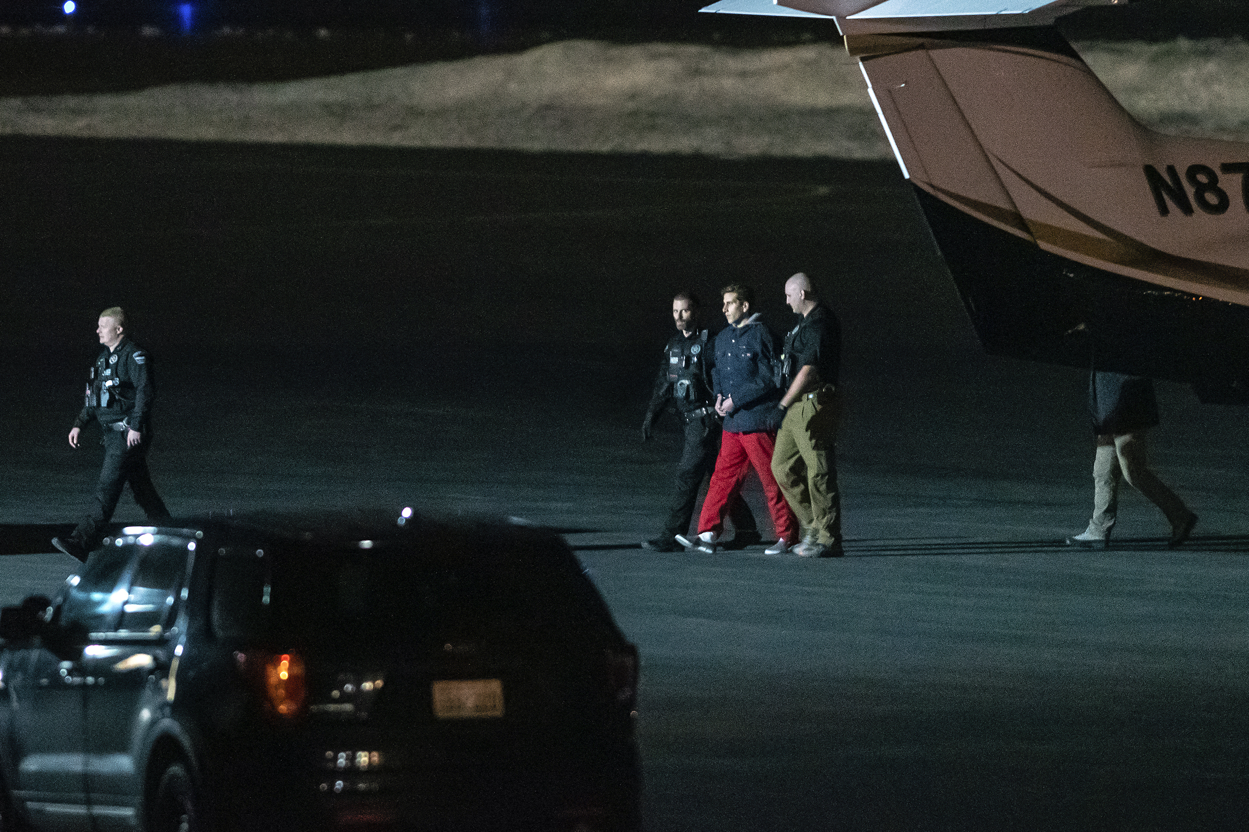 Bryan Kohberger is escorted by law enforcement after arriving at Pullman-Moscow Regional Airport on Wednesday in Pullman, Wash. Kohberger was extradited for the alleged murder of four University of Idaho students. 