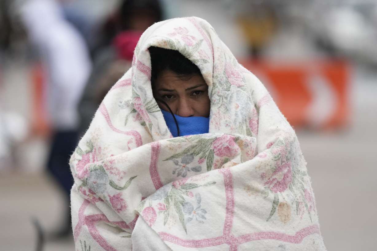 A migrant from Venezuela walks in the cold weather at a makeshift camp on the U.S.-Mexico border in Matamoros, Mexico, Dec. 23, 2022.