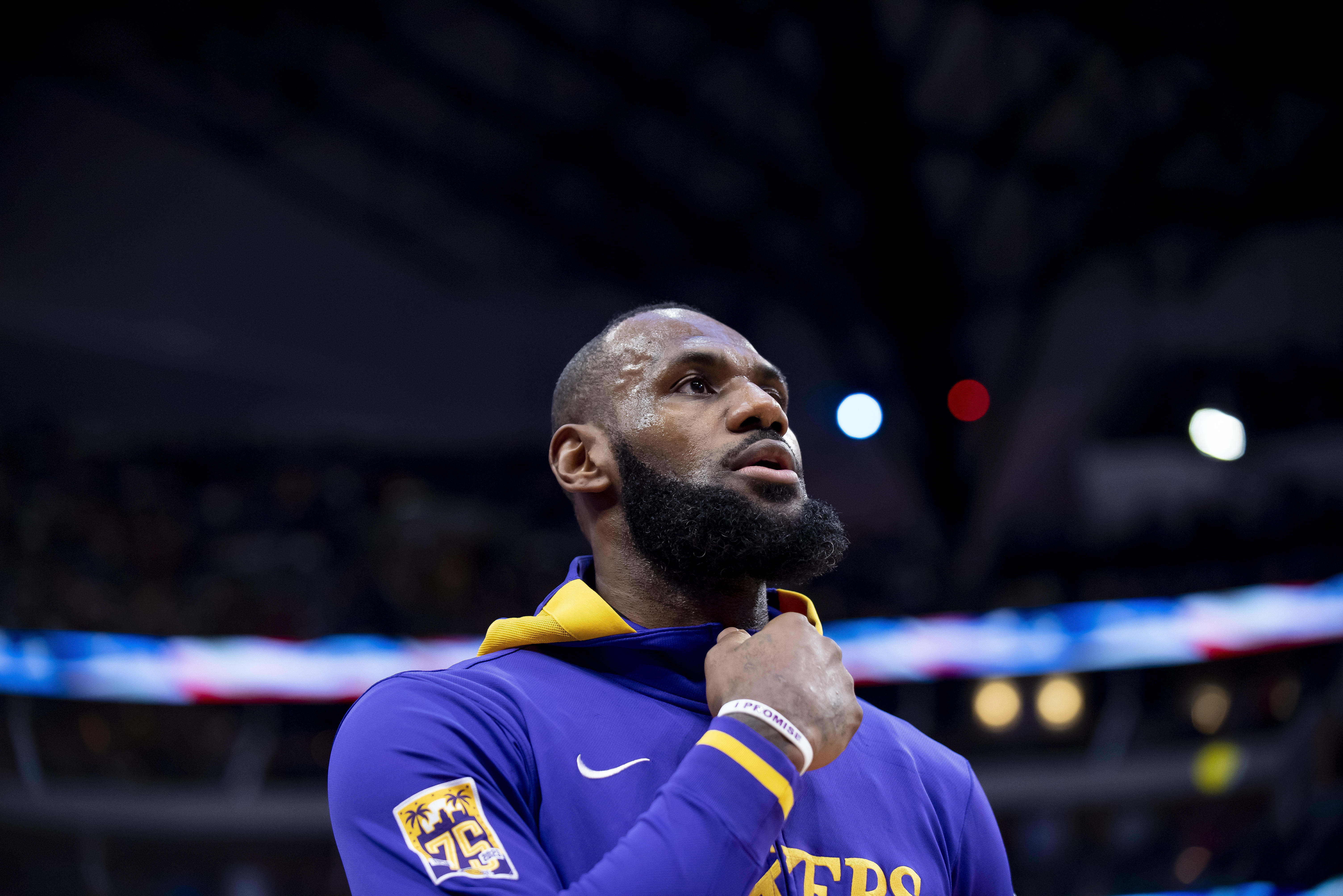Los Angeles Lakers forward LeBron James peers at the American flag during the national anthem prior to the start of an NBA basketball game in Dallas, Sunday, Dec. 25, 2022. 