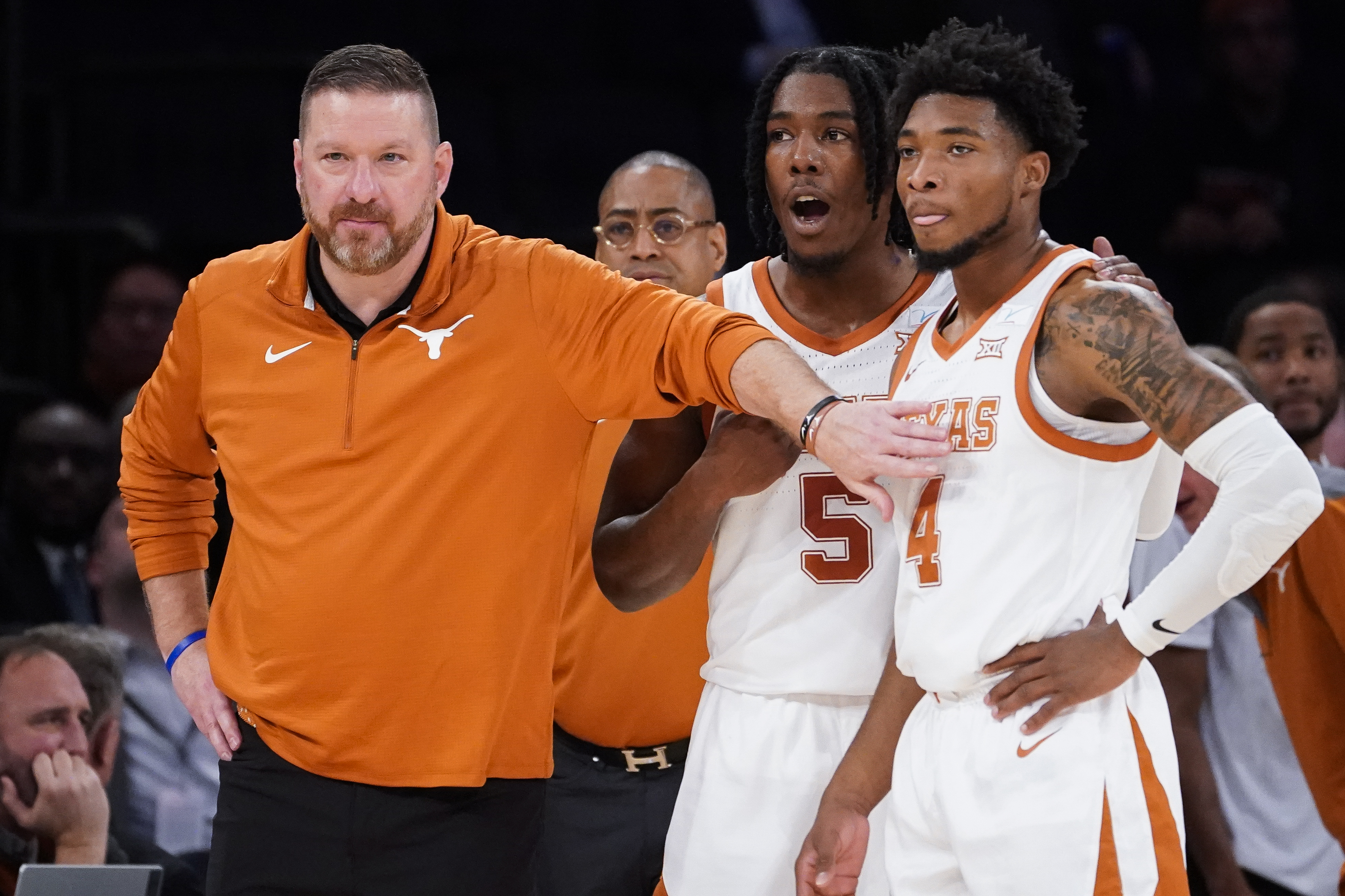 FILE - Texas' head coach Chris Beard, left, meets with Tyrese Hunter (4) and Marcus Carr (5) at the bench during the first half of the team's NCAA college basketball game against Illinois in the Jimmy V Classic, Tuesday, Dec. 6, 2022, in New York. Texas fired basketball coach Chris Beard on Thursday, Jan. 5, 2023, while he faces a felony domestic family violence charge stemming from a Dec. 12 incident involving his fiancée. 