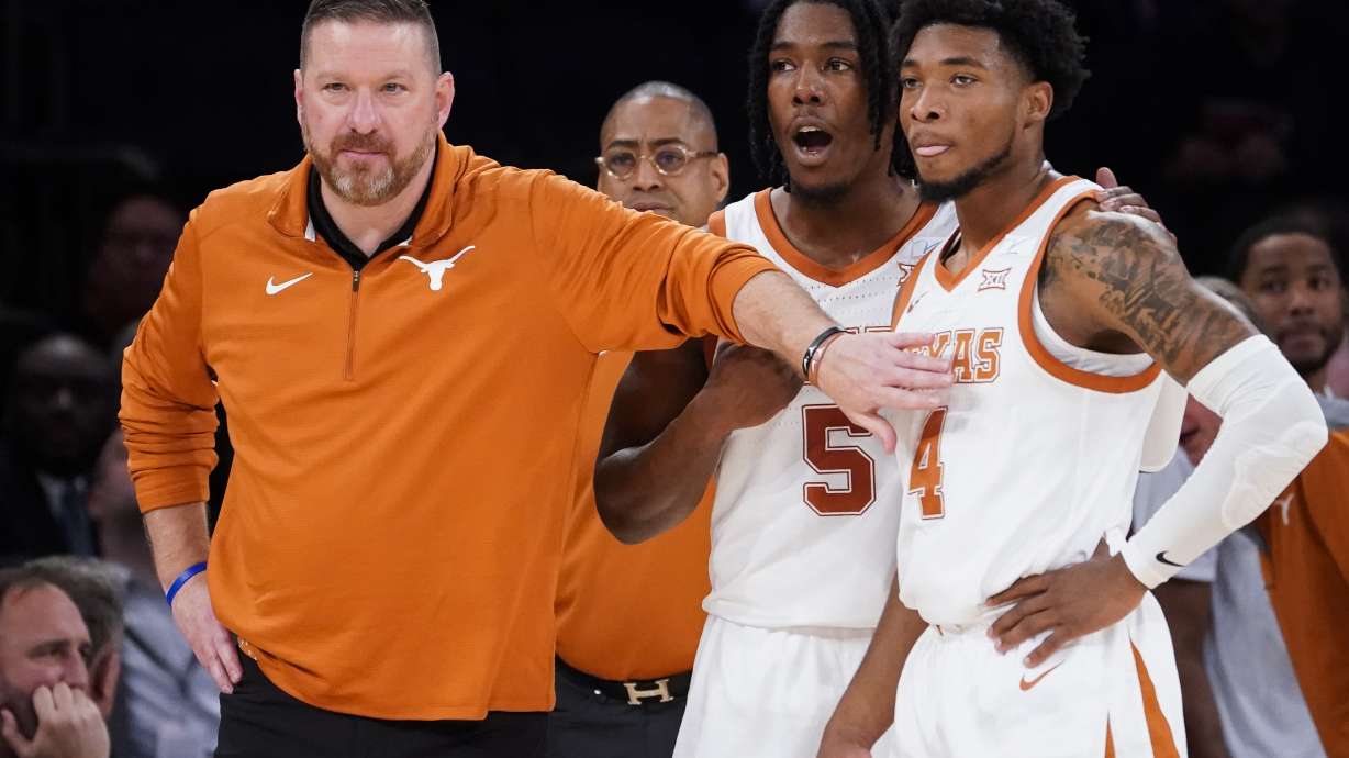 FILE - Texas' head coach Chris Beard, left, meets with Tyrese Hunter (4) and Marcus Carr (5) at the bench during the first half of the team's NCAA college basketball game against Illinois in the Jimmy V Classic, Tuesday, Dec. 6, 2022, in New York. Texas fired basketball coach Chris Beard on Thursday, Jan. 5, 2023, while he faces a felony domestic family violence charge stemming from a Dec. 12 incident involving his fiancée.