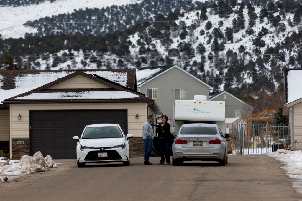 Community members talk near home in Enoch, Iron County, where police say 42-year-old Michael Haight killed his wife, Tausha Haight, 40, and Tausha’s mother, 78-year-old Gail Earl, and his five children — a 17-year-old female, 12-year-old female, 7-year-old female, 7-year-old male and a 4-year-old male — before taking his own life, on Thursday.