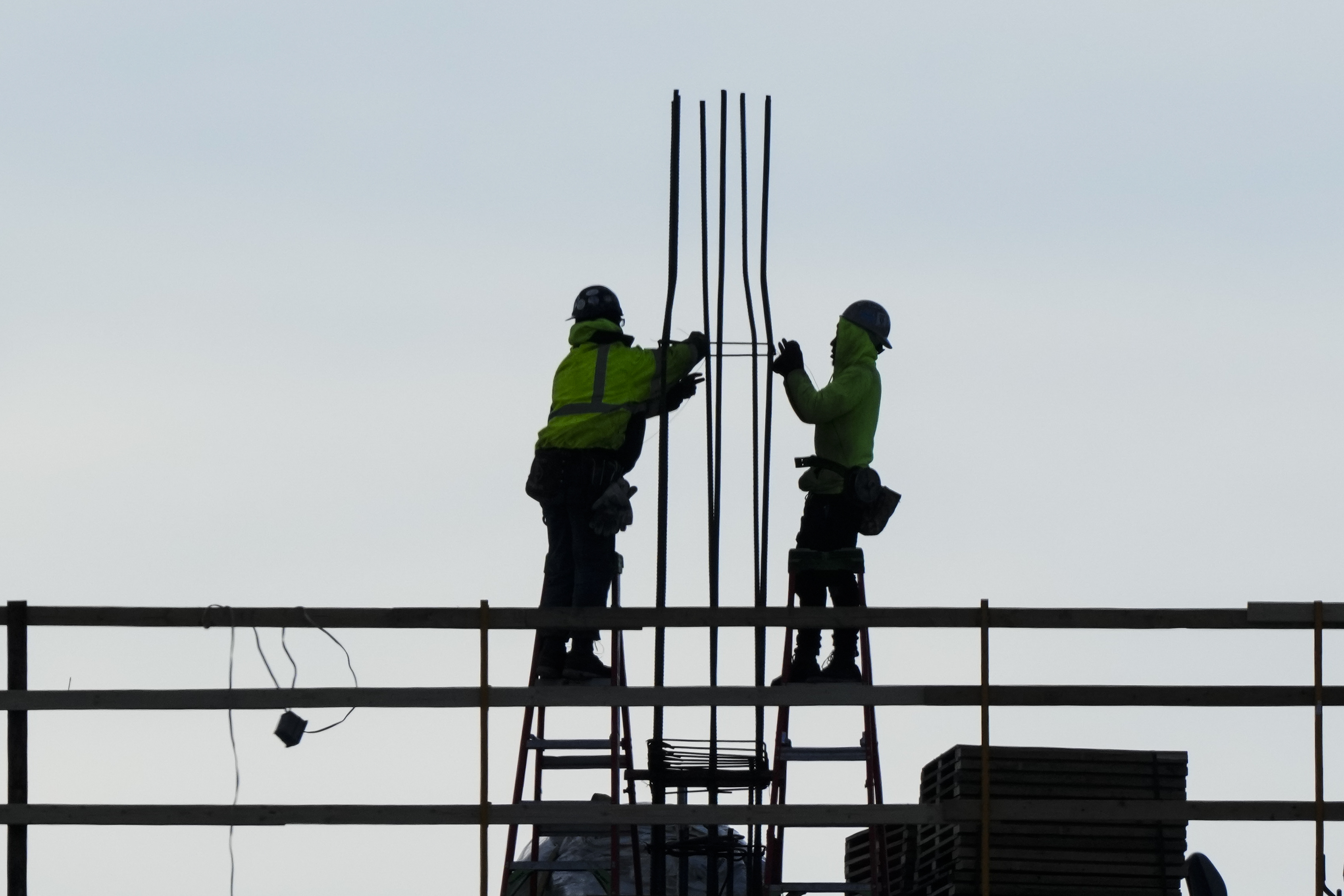 Construction workers work on a building in Philadelphia, Dec. 21, 2022.