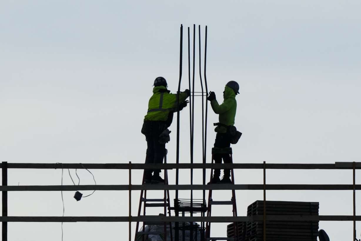 Construction workers work on a building in Philadelphia, Dec. 21, 2022.