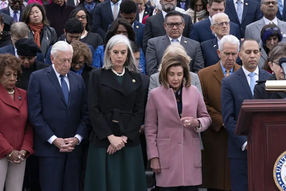 Incoming House Minority Leader Hakeem Jeffries, D-N.Y., accompanied by from left, Rep. Maxine Waters, D-Calif., Rep. Steny Hoyer, D-Md., incoming House Minority Whip Rep. Katherine Clark, D-Mass., Rep. Nancy Pelosi, D-Calif., along with members of Congress and family of fallen officers, pauses for a moment of silence during a ceremony marking the second year anniversary of the violent insurrection by supporters of then-President Donald Trump, in Washington, Friday.