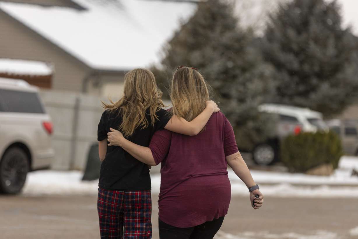 Community members walk away from a memorial that was created outside of a home in Enoch, Iron County, where police say 42-year-old Michael Haight killed his wife, Tausha Haight, 40, and Tausha’s mother, 78-year-old Gail Earl, and his five children — a 17-year-old female, 12-year-old female, 7-year-old female, 7-year-old male, and a 4-year-old male — before taking his own life, on Thursday.